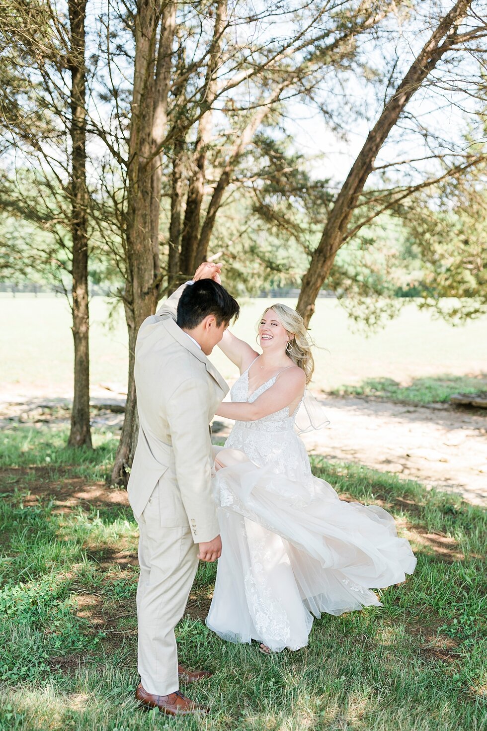  Dancing and laughing together after this wonderful couple tied the knot during their romantic and intimate backyard wedding! Romantic casual lace wedding gown close friends neutral colors background wedding natural greenery crisp white #midwestphoto