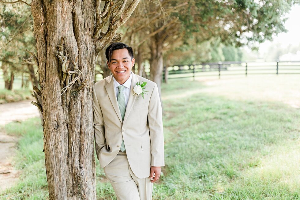  This handsome groom posed for a couple photos taken after such an intimate backyard wedding where he married the love of his life! Romantic casual lace wedding gown close friends neutral colors background wedding natural greenery crisp white #midwes