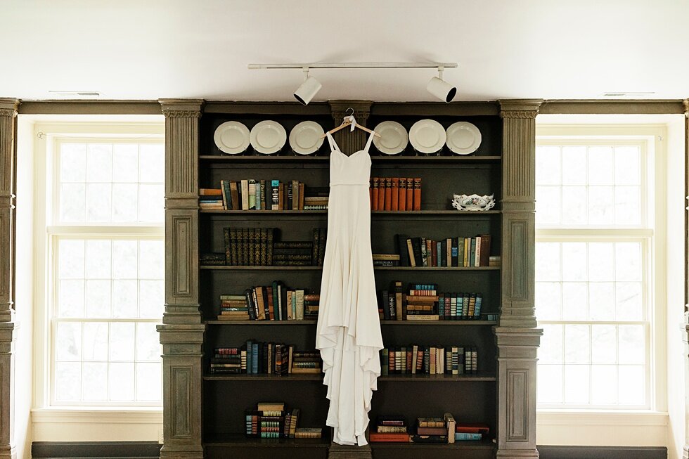  Stunning white wedding gown hung from the ceiling with a bookshelf back drop and bright accent pieces throughout the room. Kentucky wedding photographer wedding bliss just married love ceremony inspiration garden wedding intimate #farmingtonhistoric