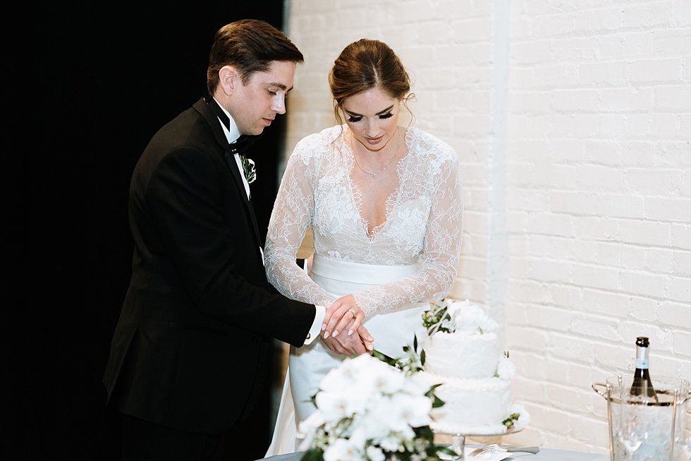  Bride and grrom cuting cake at wedding reception. Lauren and Adam's winter wedding at St Agnes Catholic church and the Frazier History Museum. 