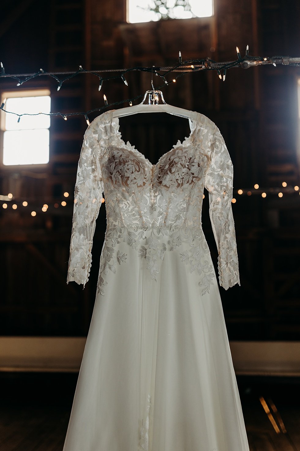  Bride's dress and details. Wedding dressing hanging in barn. Outdoor summer wedding at Villwock Farms , Edwardsport, IN 