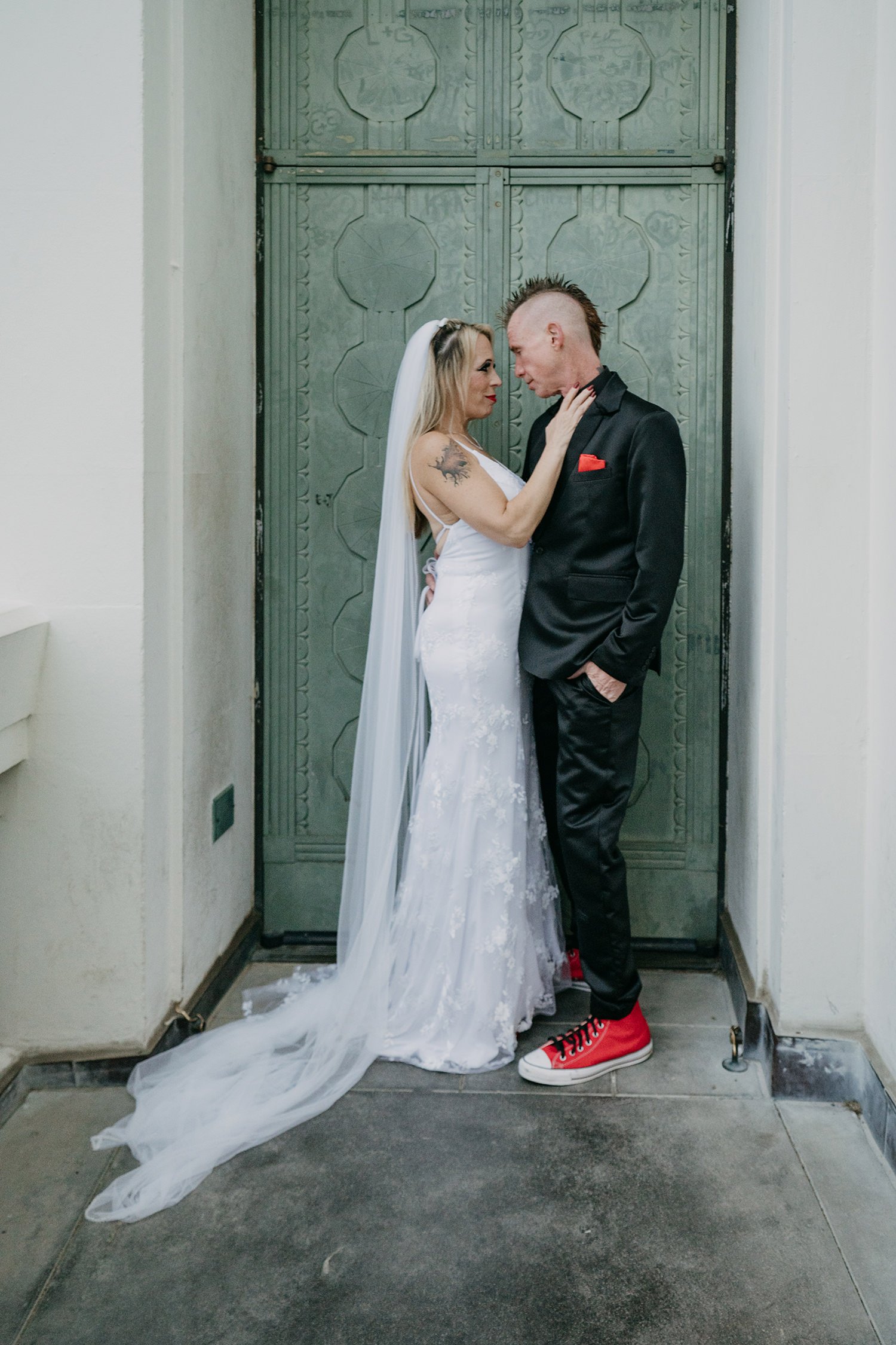 Couple posing in front of green door at Griffith Observatory