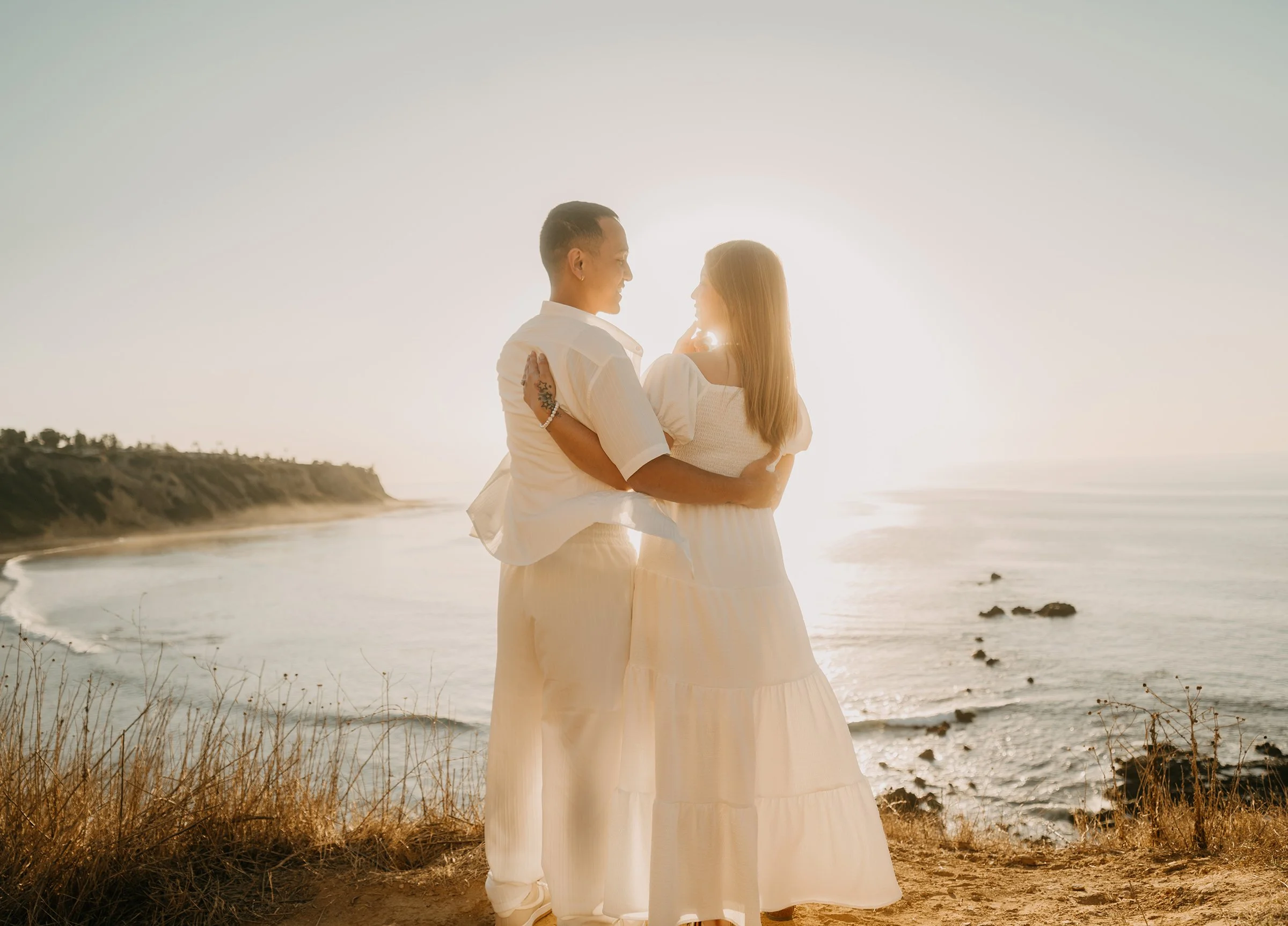 Christian and Stephanie embracing during a sunset engagement session at Bluff Cove in Palos Verdes Estates, California