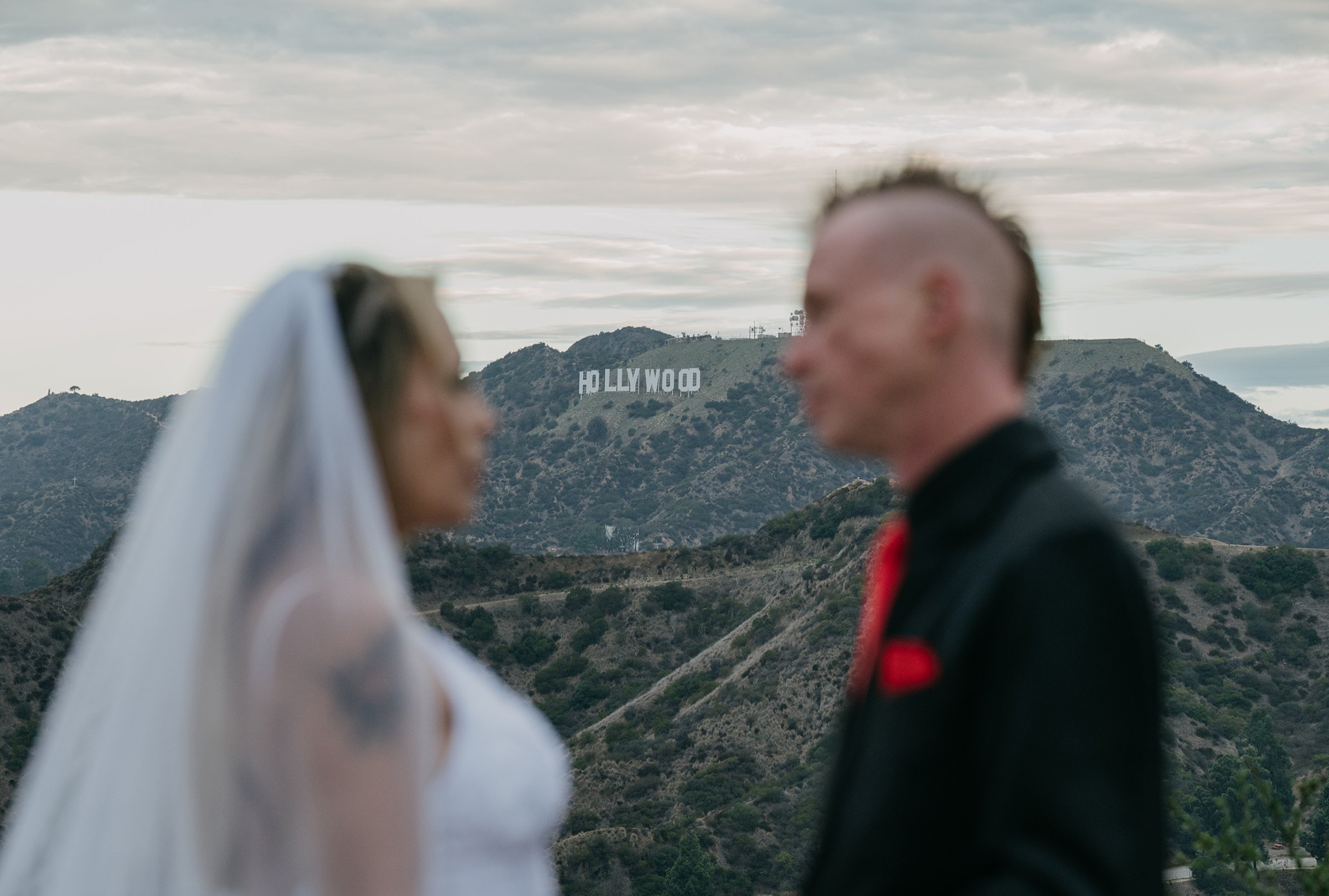Newlyweds posing with the Hollywood Sign in the background