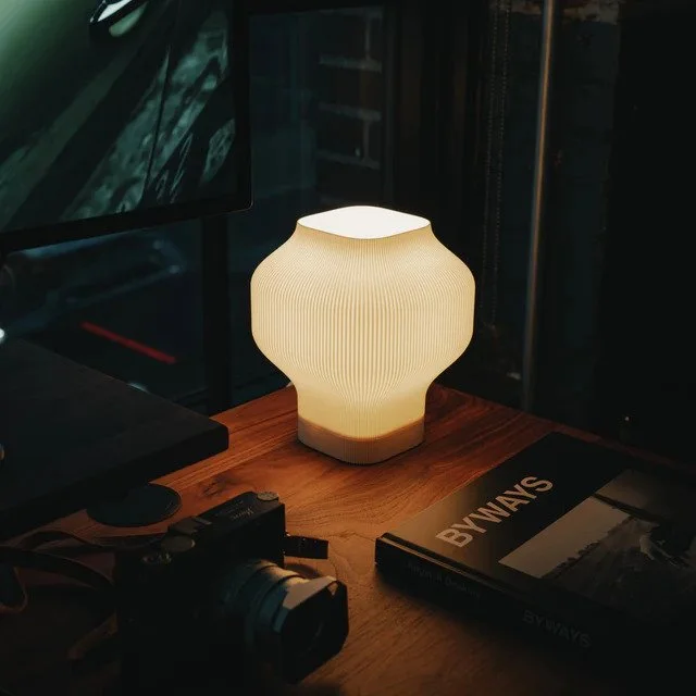 Minimalist Nomi Lamp on a desk creating soft ambient lighting