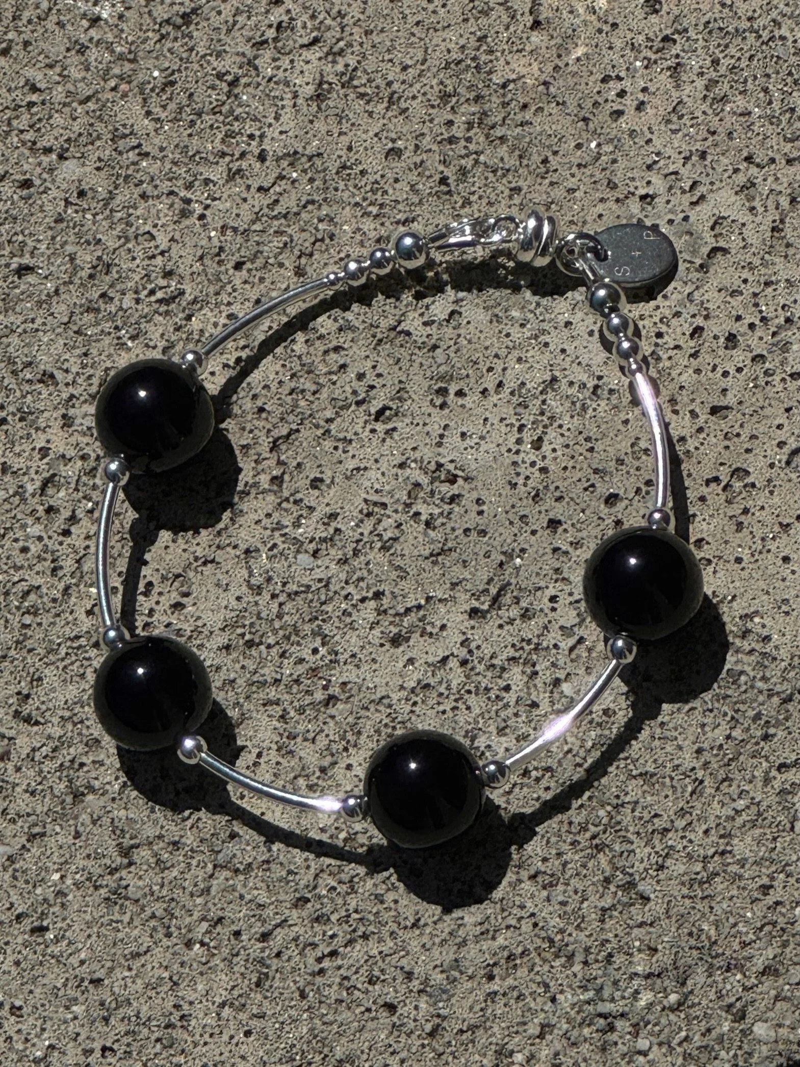 S+P arc onyx bracelet. Made of 12mm onyx beads and sterling silver tube beads. Online now