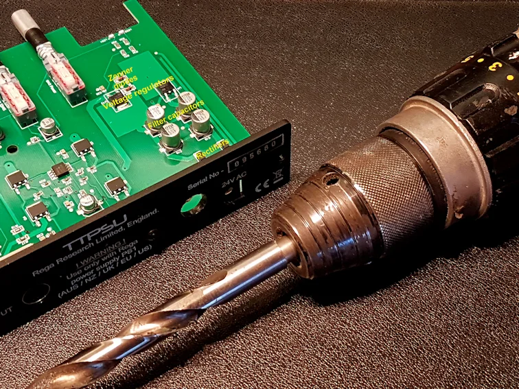 A large drill and surface mount electronics...What could possibly go wrong! A cable gland will replace the flimsy DC socket when we hard-wire the transformer.