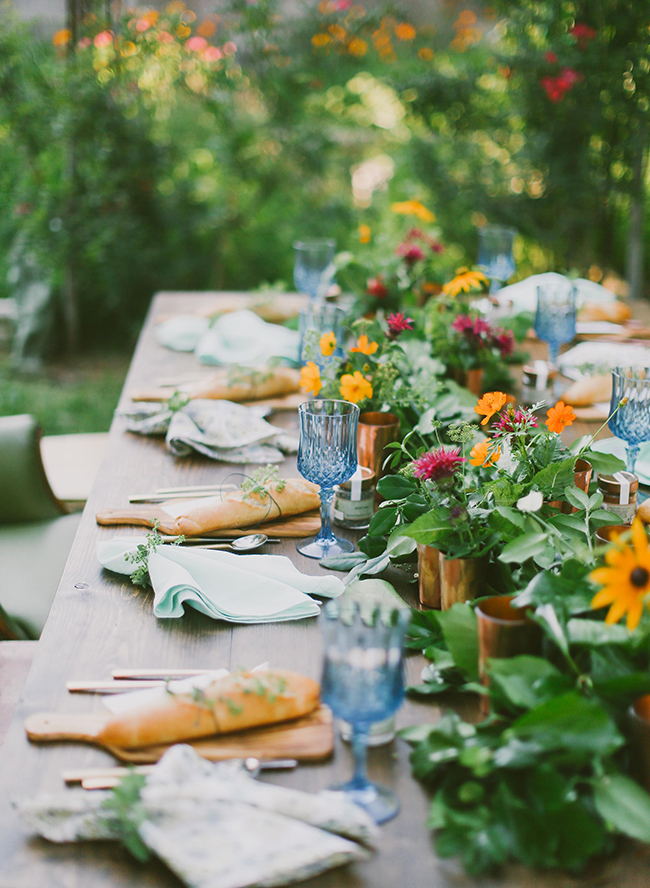 Photo: Inspired by This Here is another beautiful example of a Farm to Table themed tablescape - this one with perfect sized wooden cutting boards as the plates and a multitude of copper vases to hold brightly colored flowers and greenery is absolutely beautiful! 