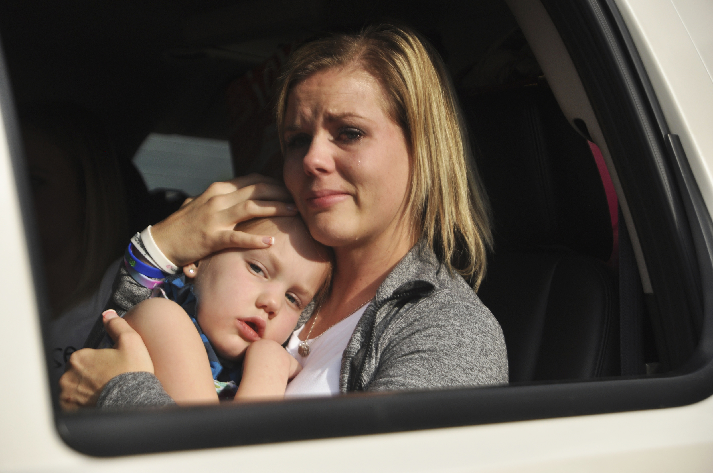With tears streaming down Jamie's cheeks, mother and daughter listen to the beautiful voices of the children singing to Kycie.