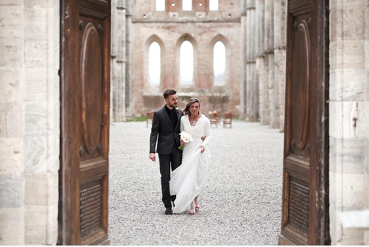  Intimo matrimonio invernale nella splendida cornice della basilica di San Galgano, a Chiusdino in provincia di Siena. Un rito civile sancito dal sindaco sotto il cielo, in quanto la struttura è priva di tetto. Un luogo magico, un allestimento florea