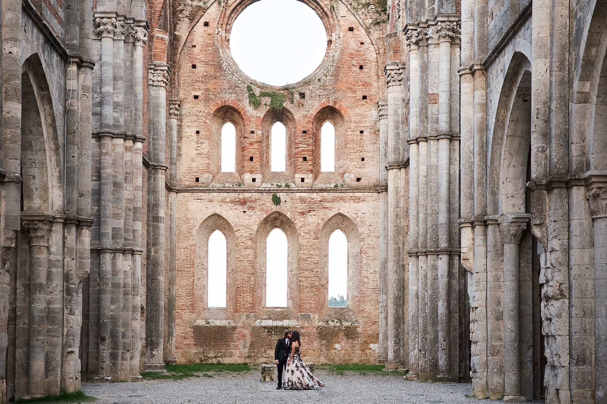  An intimate wedding in the charming Abbey of San Galgano, characterized by the lack of a roof. The civil ceremony celebrated by the Mayor took place on a rainy day, but always with emotion. Particularly the bride's dress with beautiful black embroid