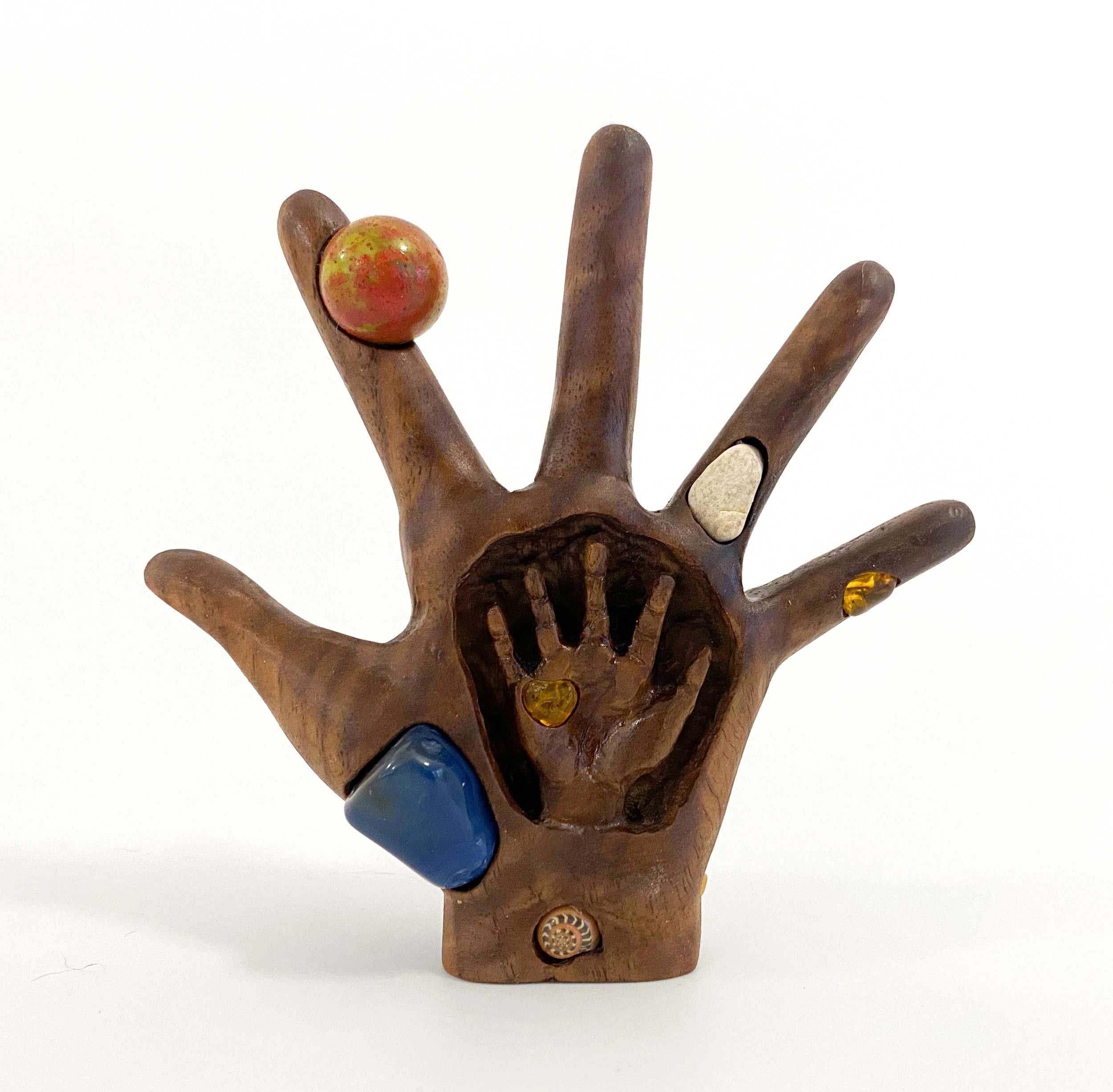   Hand with Small Hand , 2023, rocks, amber, marble, shell, and fossil on carved walnut, 4.5” x 4.5” x 1.5” 