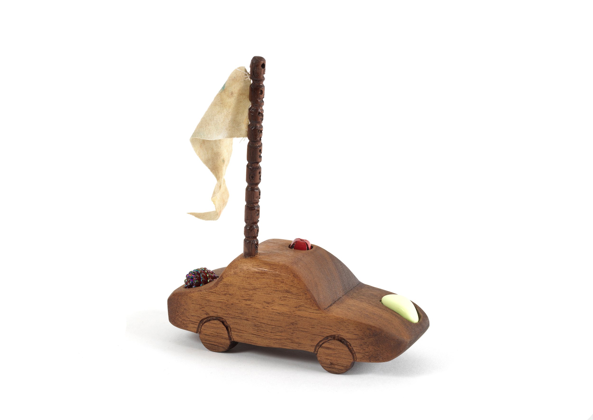   Sedan with Flag , 2020, cloth, string, rock, bell, and bead on carved walnut, 5.25” x 2” x 4.5” 