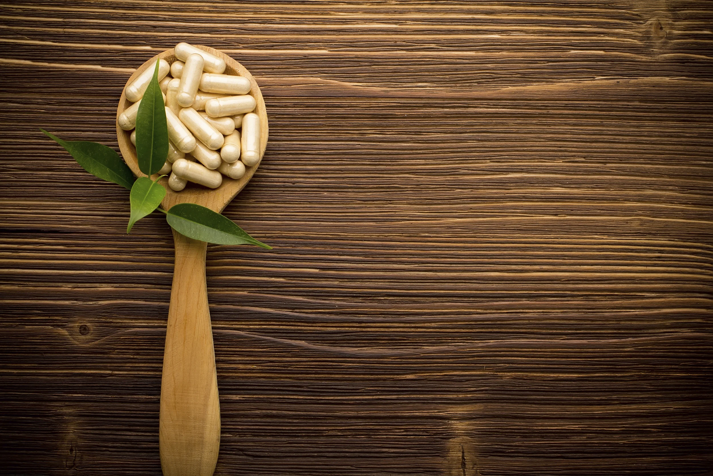 Supplements in a wooden spoon - 186676333.jpg
