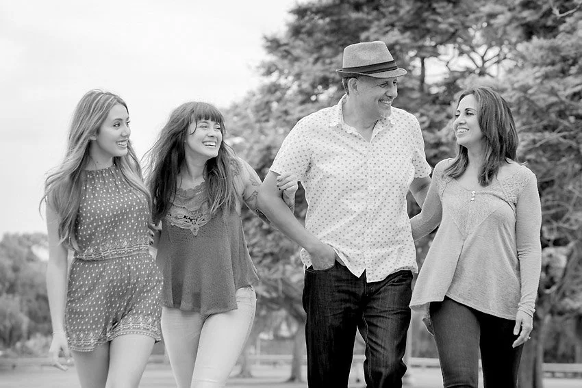 Family having fun in a park walking towards a camera