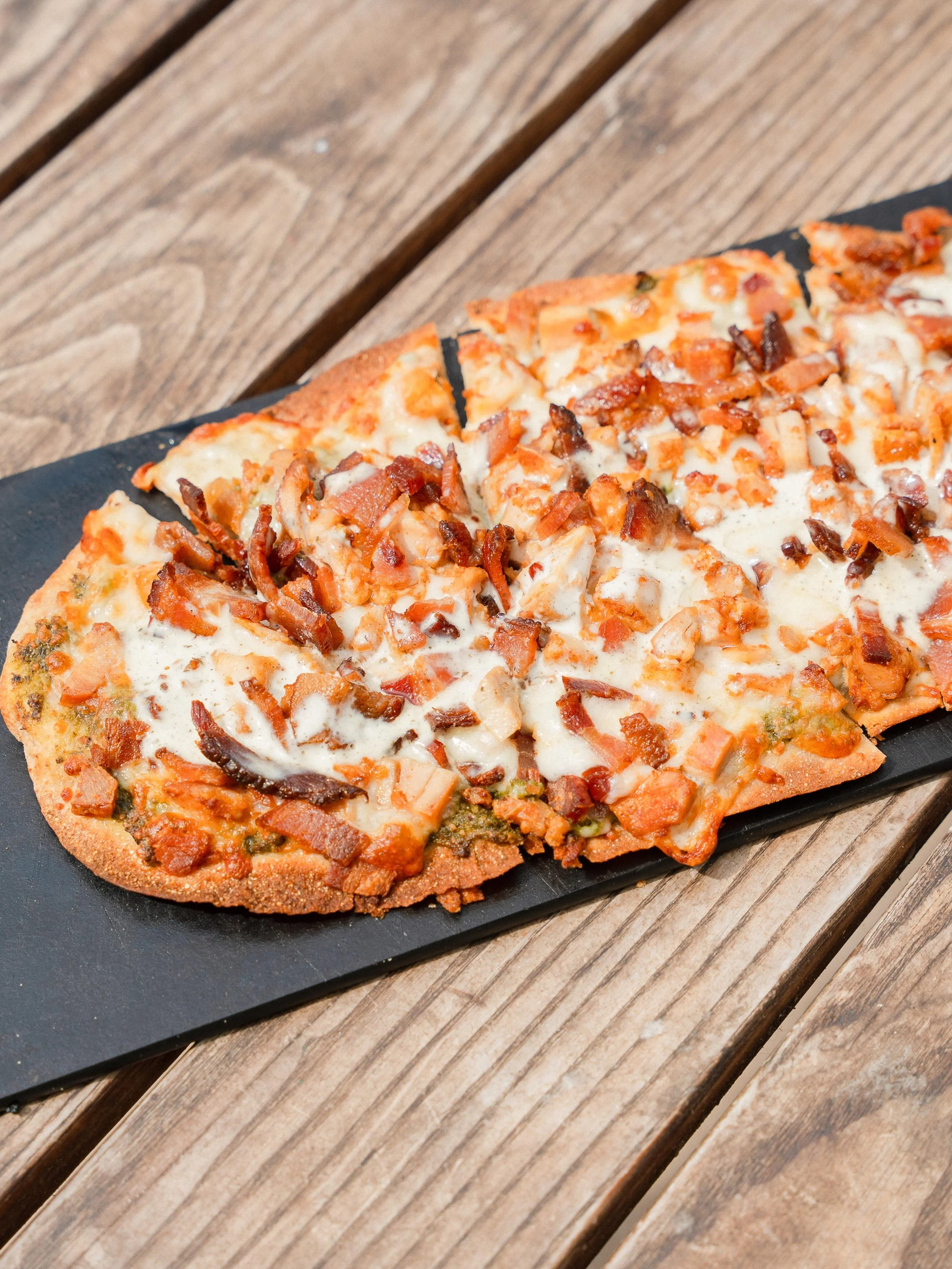 Pizza, but the Ferm Farm way! Gut-friendly made with our long fermented sourdough flatbread, sprouted almond pesto, grass-fed mozzarella, pastured chicken &amp; bacon, and topped with a kefir ranch drizzle. Seed oil-free, and made from scratch. Send 