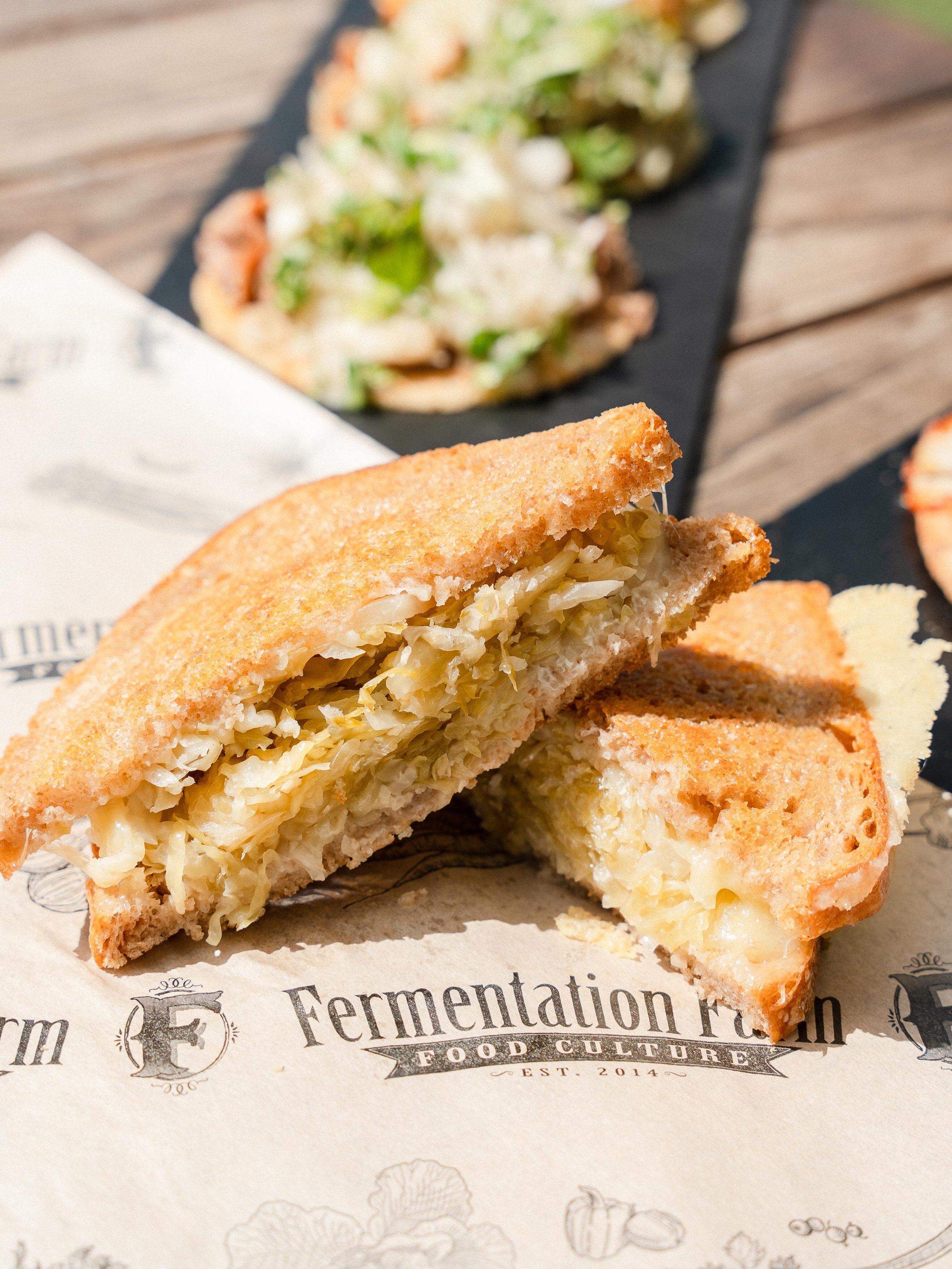 If you have not tried our Kraut Grilled Cheese...you are missing out. Crafted on our long-fermented sourdough, layered with house-made kraut (plain, garlic, or spicy) and raw cheese &mdash; then pressed until golden. A grilled cheese that actually is