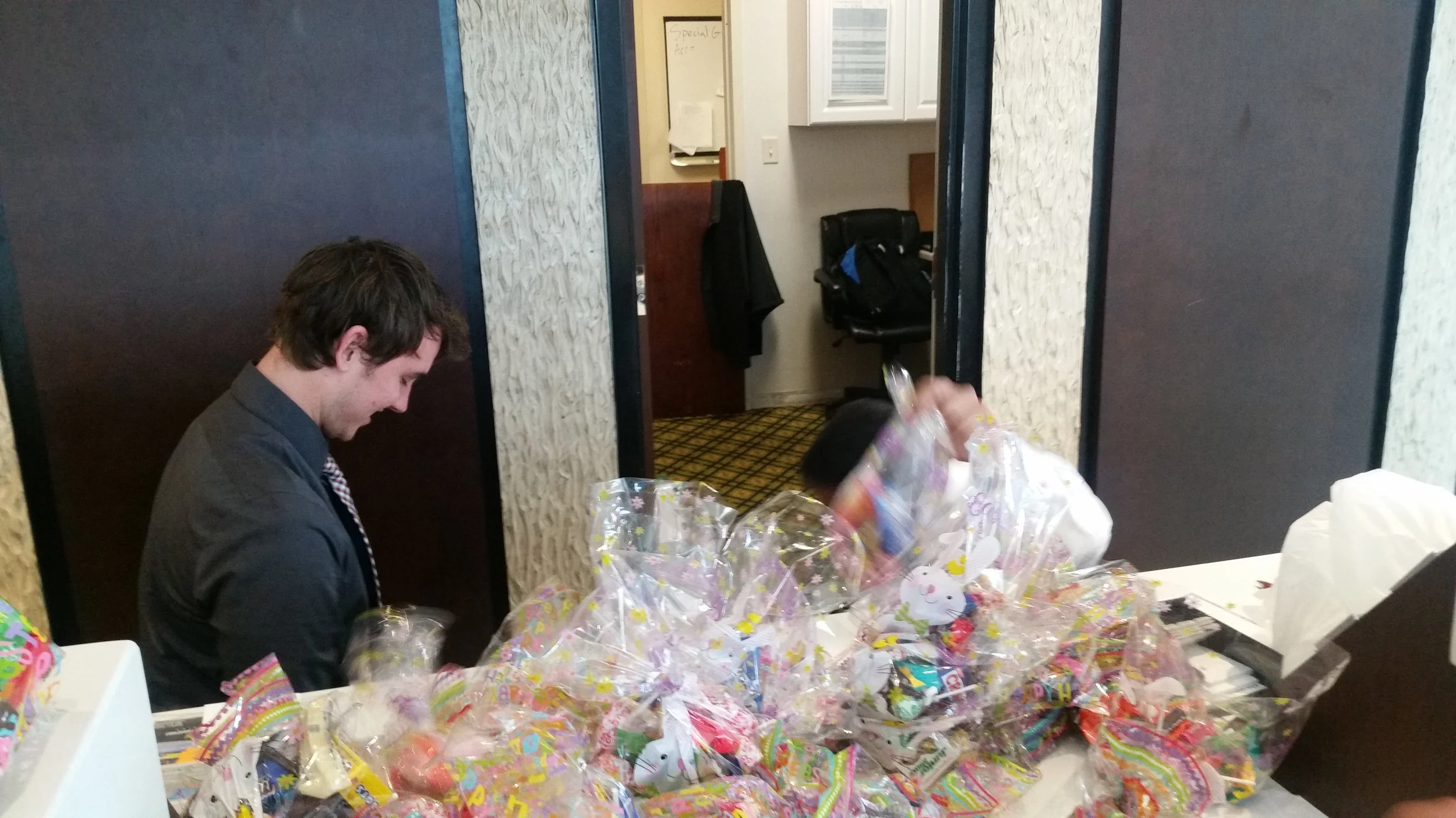 Front desk associate Nicholas getting all the candy bags ready to take to primary children's hospital .