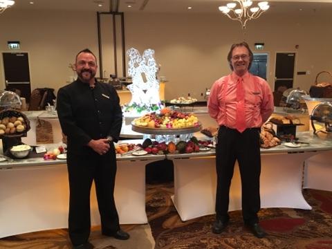 Banquet server Jim and Director of banquets Gene posing for a picture in front of the Mother's Day Scuplture.