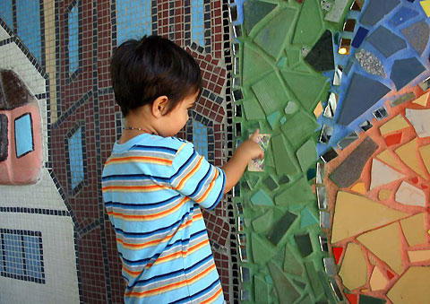 A child finds the tile he put on with his parent’s help.