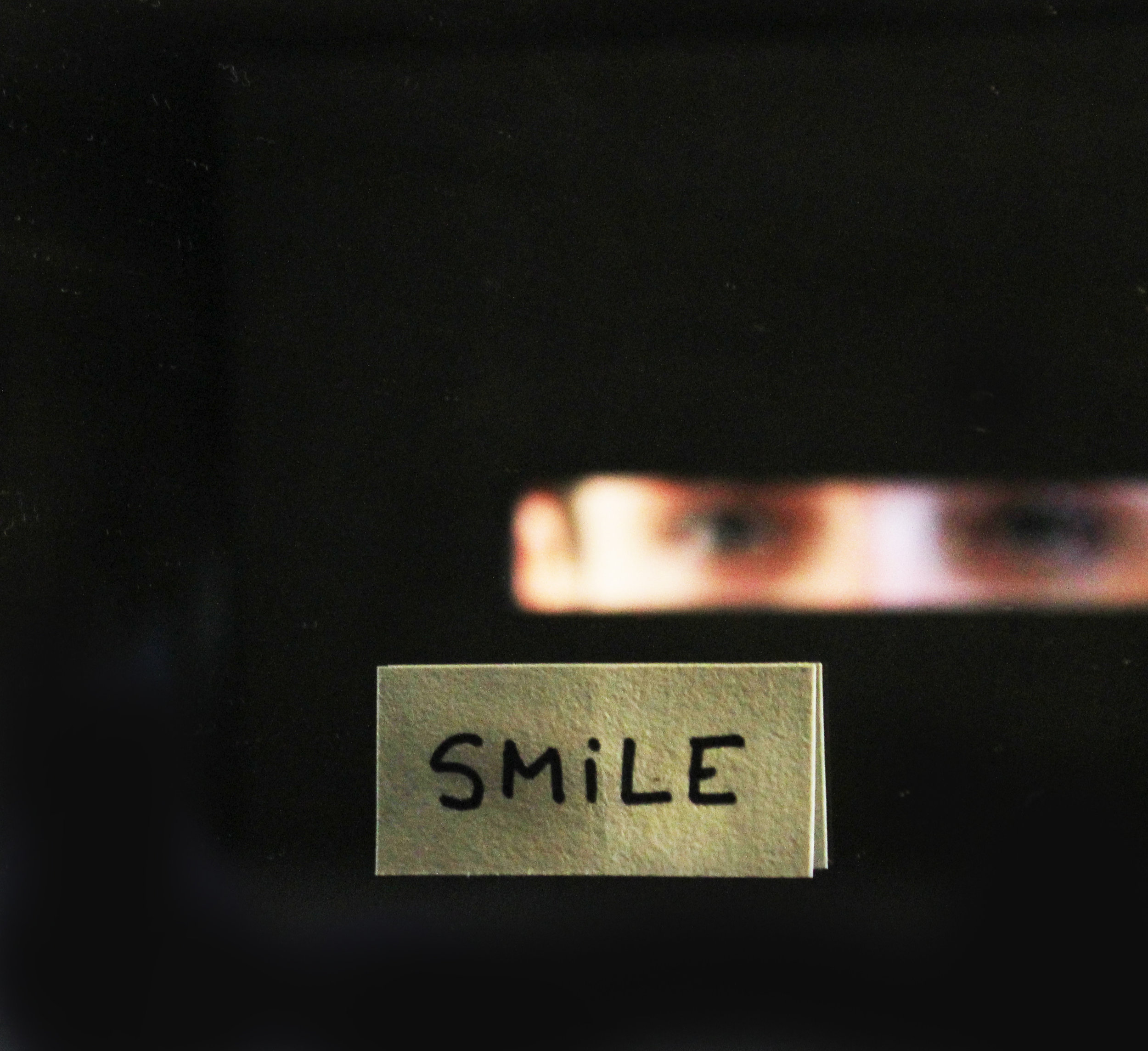  Box of smiling eyes, 2014  Closed painted wooden box with a small peephole to look inside the box and see your own eyes reflecting in a mirror and the word SMILE. 