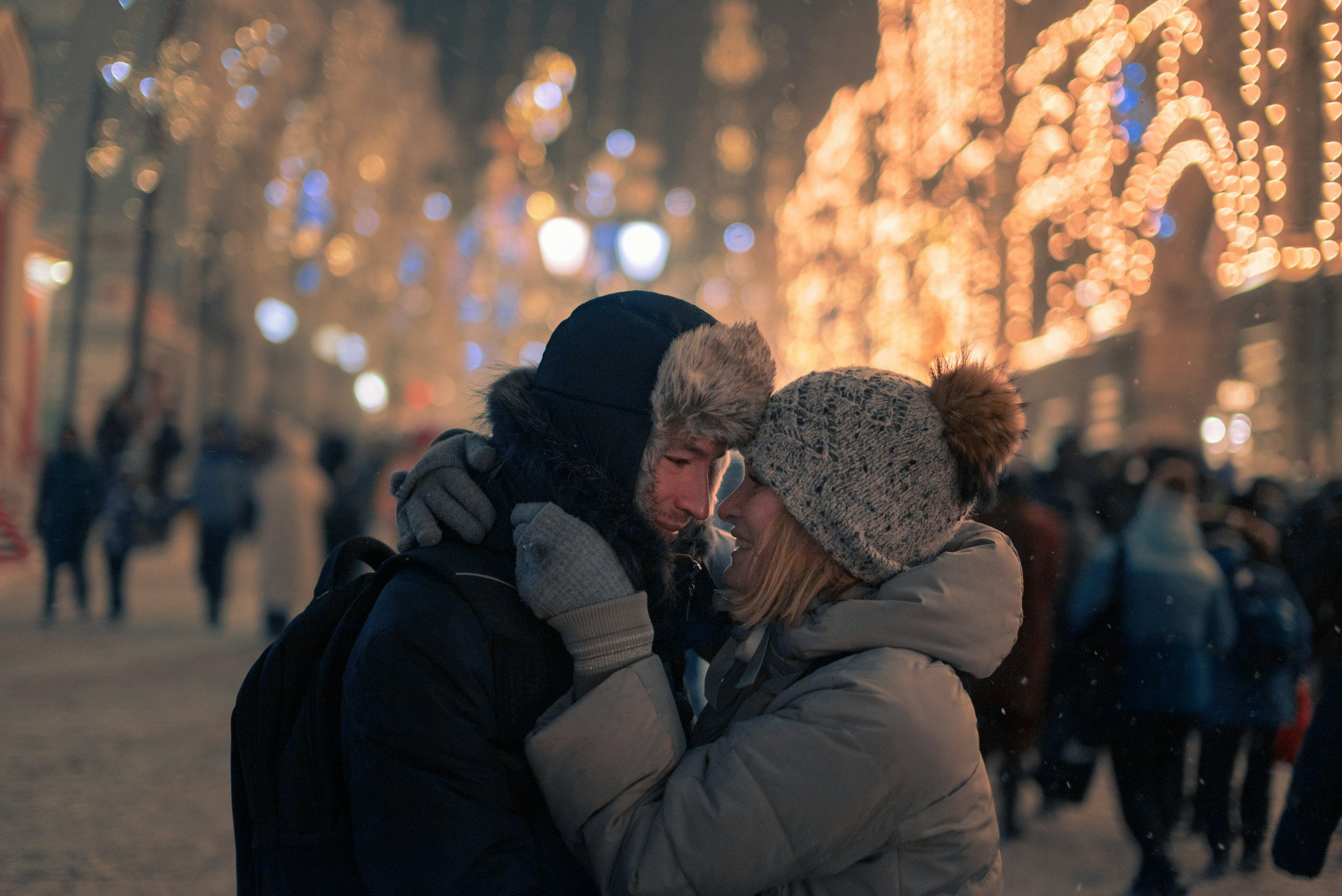 festive-christmas-couple-embracing-winter-lights.jpg