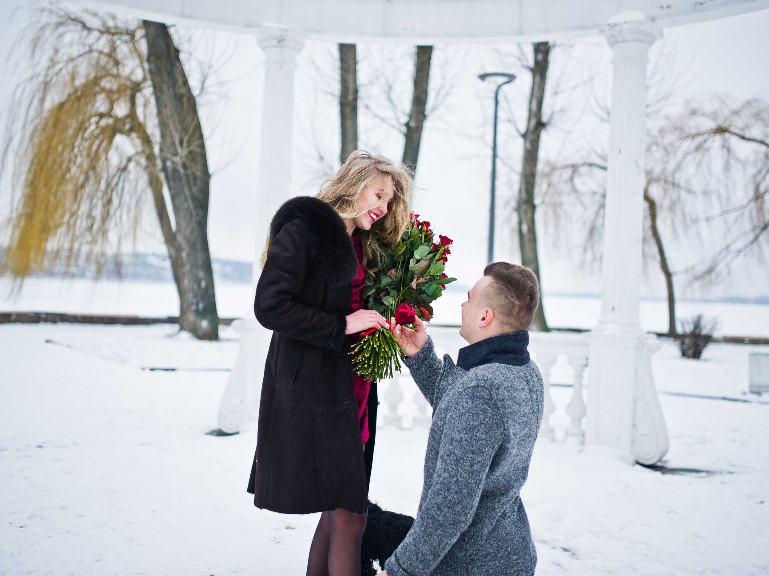 Couple getting engaged during a winter proposal in a snowy outdoor setting