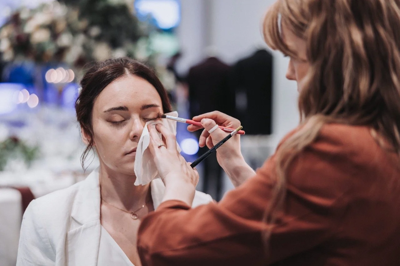 Makeup artist applying bridal makeup during a live demonstration at a Red Event wedding fayre