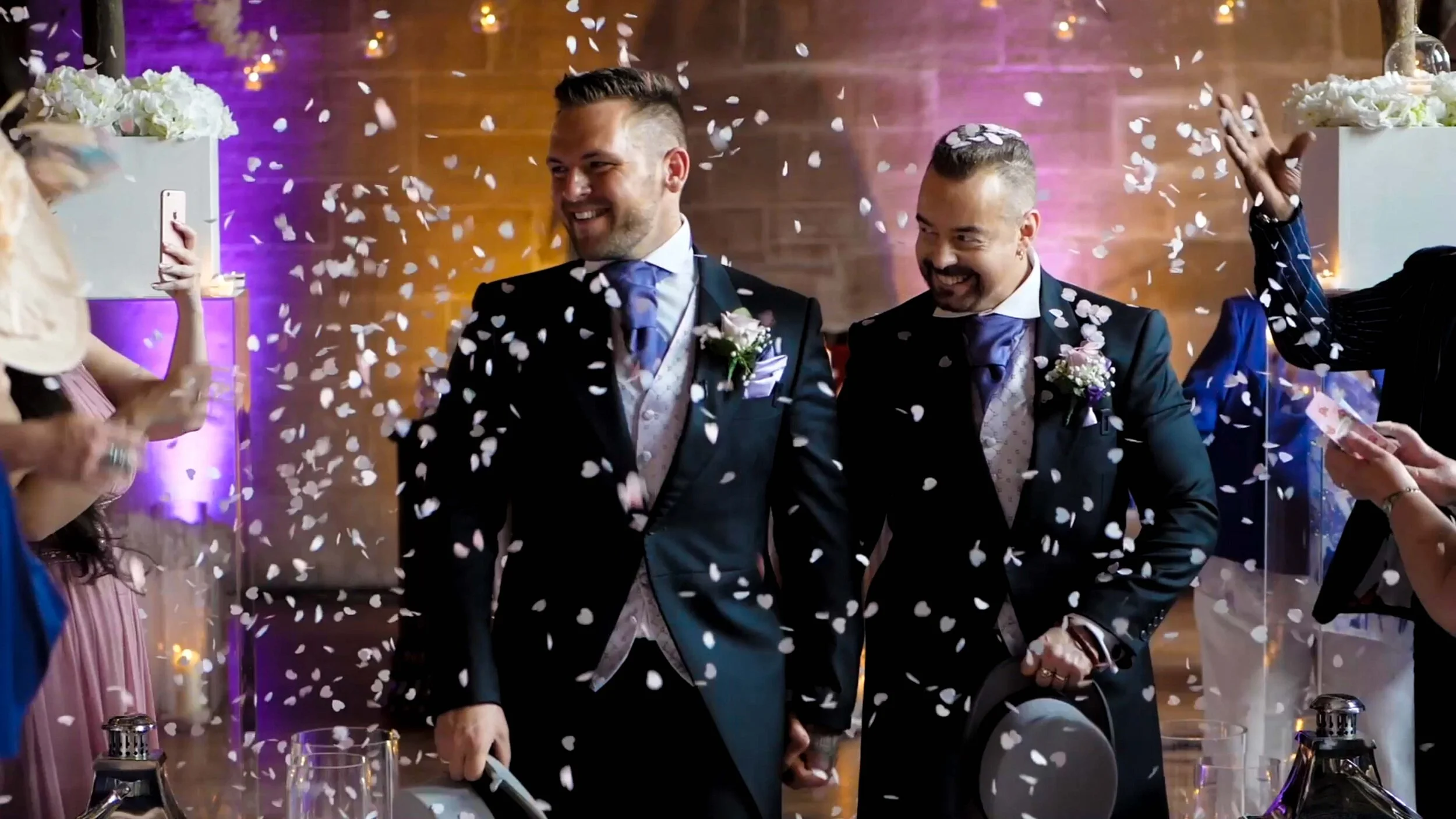 John and Jason share their walk down the aisle at the stunning Peckforton Castle. Confetti rains down upon them, as guests cheer their exit as husband and husband.