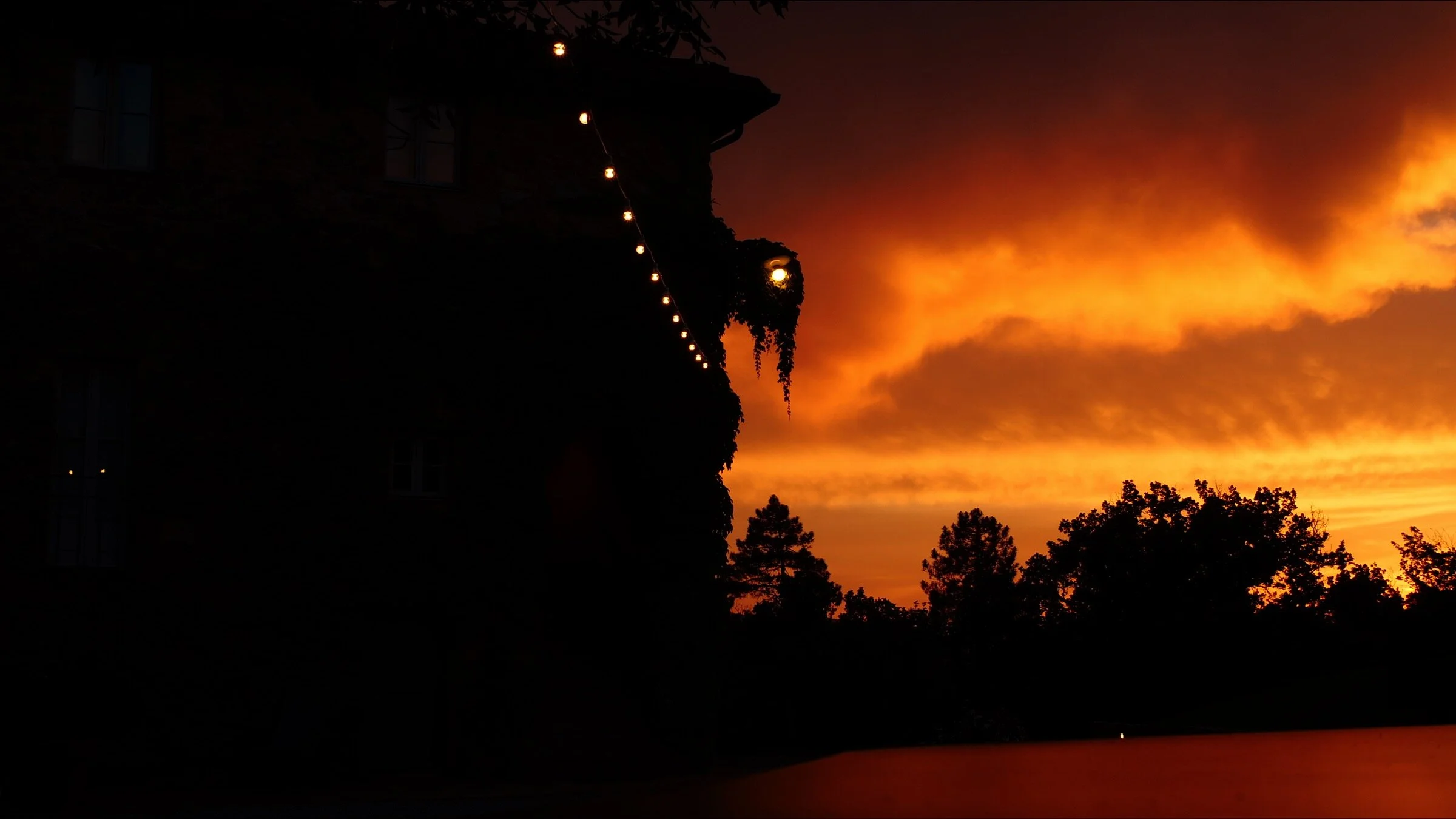 A rich, golden sunset falls behind Villa Podernovo, which is silhouetted against the sky. .