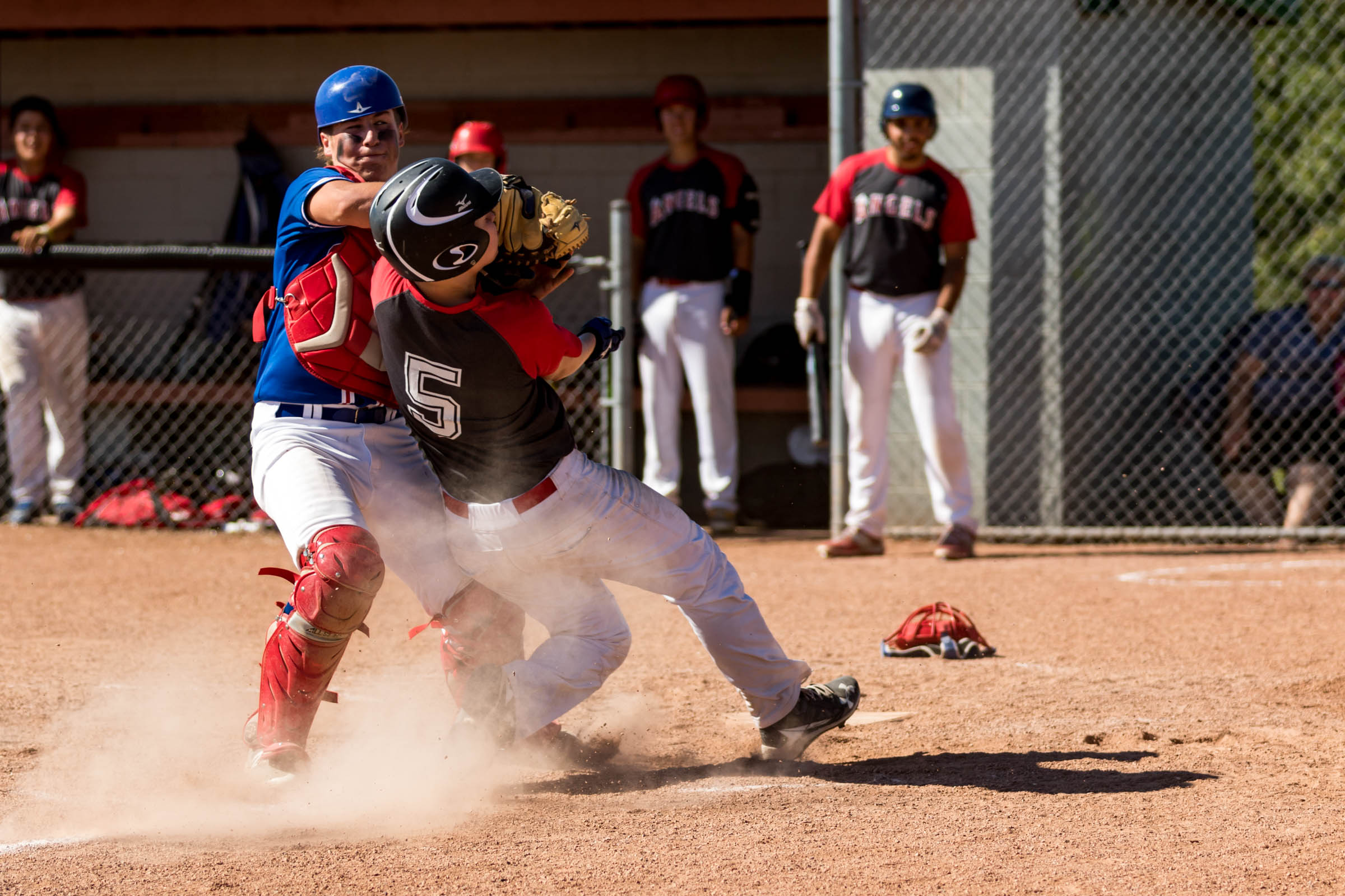 The definition of a play at the plate in baseball has changed recently, for player safety reasons. No longer are runners allowed to go through catchers and catchers can no longer block the plate. Sometimes though, things just kind of happen. Like this collision between the Camrose Cougars (blue) and the Edmonton Angels (black) at Midget AA Provincials | July 29 at Four Seasons Park, Beaumont