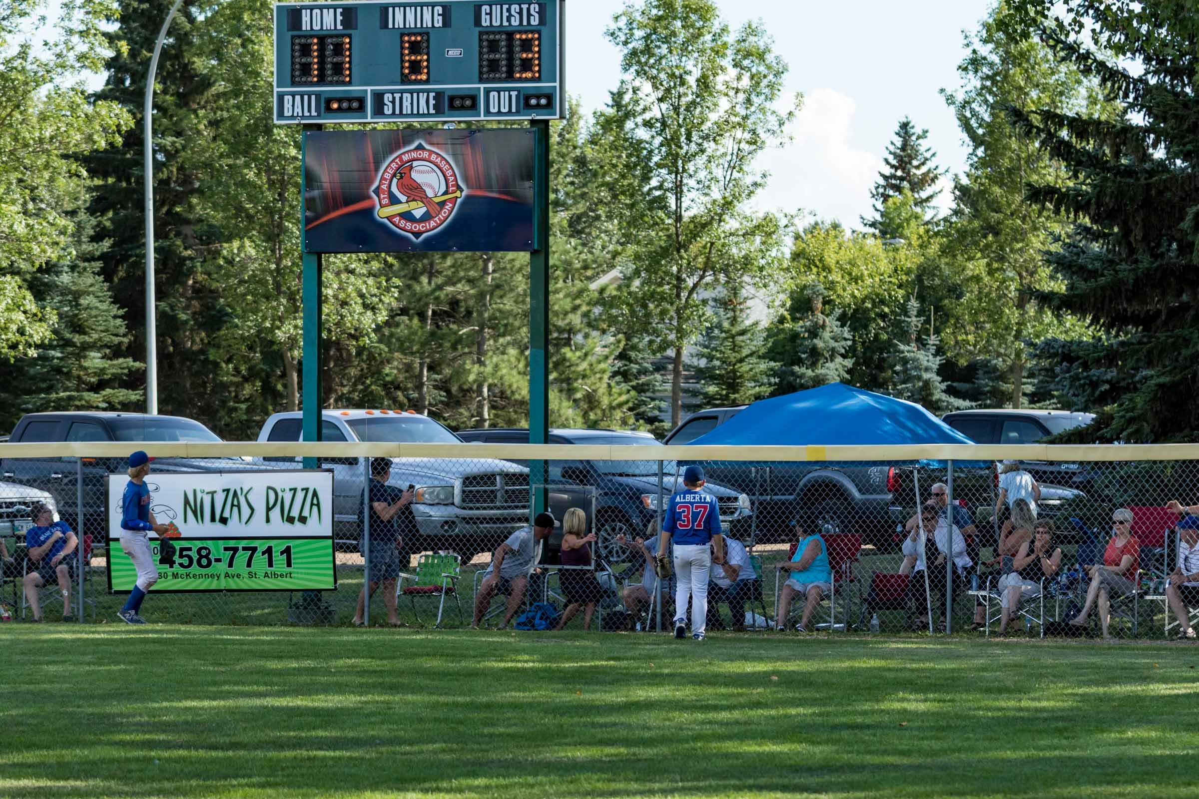 As you can see on the scoreboard the Peewee AA Western Canadian Championship game was a little bit of a runaway. In fact this home run was a walk off mercy win for Winkler (MB) over the Camrose Cougars. The crowd beyond the fence was watching in amazement at the distance and the intrigue to see who's vehicle it would land on | August 14 at Legion Memorial Ballpark, St. Albert
