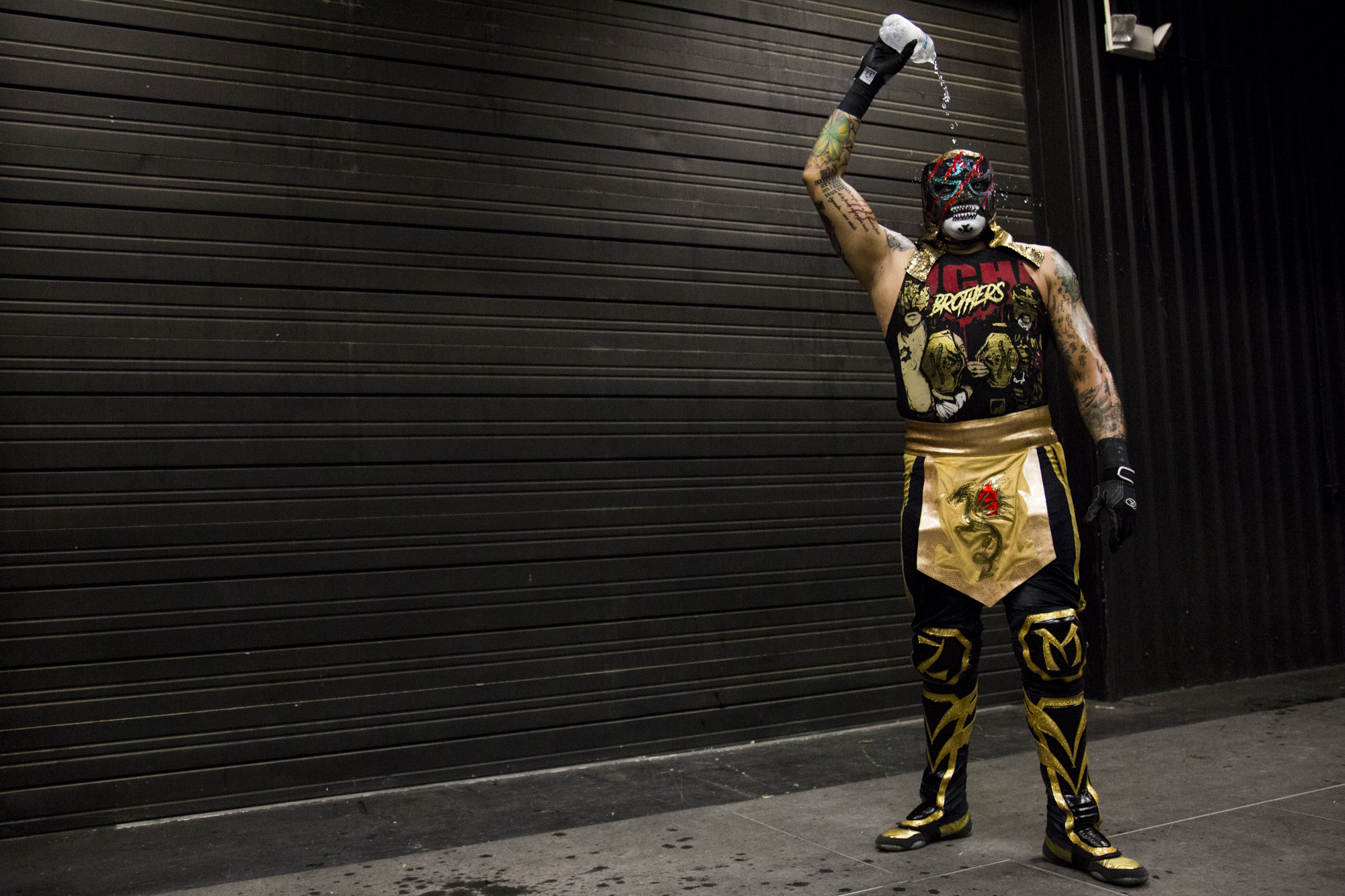 Luchador Pentegón Jr. pours water over himself before heading out to the ring to fight his opponent Réy Fenix during Live Lucha Libre at the Victoria Community Center in Victoria, Texas on July 23, 2017.
