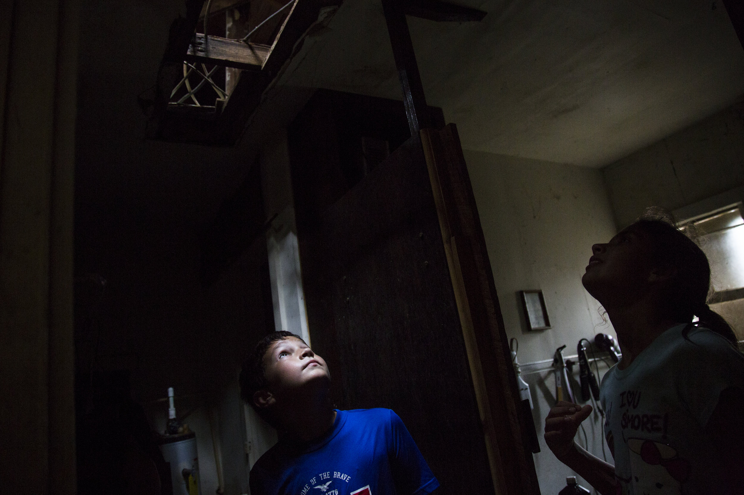  Kyler Carpenter, 10, left, and Laela Carpenter, 11, look up through a hole that was torn in their roof by Hurricane Harvey. The cousins surveyed the damage on Aug. 27, 2017 to Laela’s family home in Bayside, Texas. 