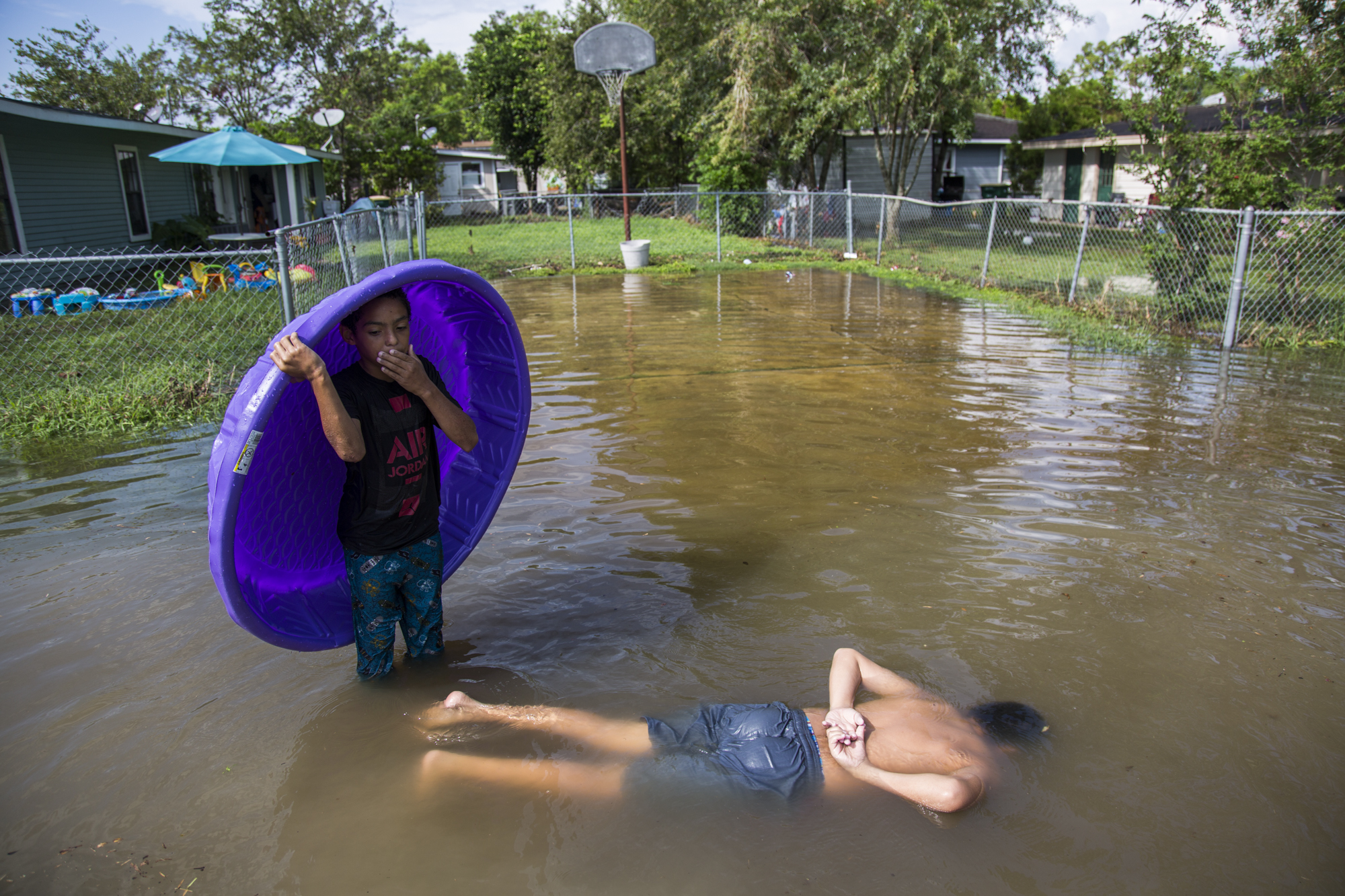 Jeffery Kichen, 9, left, counts out loud to keep track of how long Xavier Salazar, 12, can hold his breath underwater. The city of Victoria, Texas was hit with a rain storm that caused sudden flooding throughout the city due to the already over-saturated ground from Hurricane Harvey.