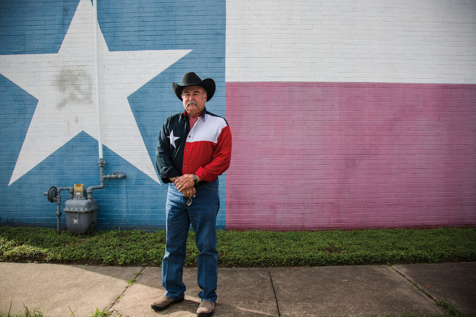  Thomas Smith, 66, stands in front of a Texas flag wall painting with a matching Texas flag shirt before the start of the Veterans Day parade in Victoria, Texas on Nov. 11, 2017. 