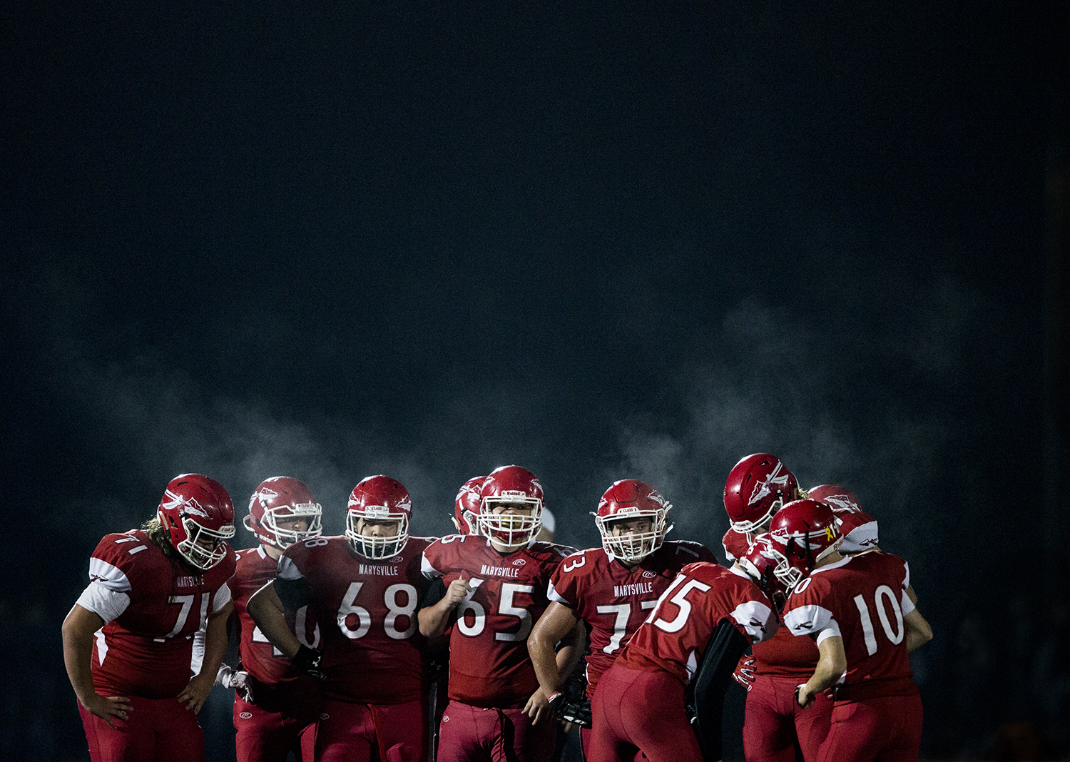  Steam from Marysville-Pilchuck player’s breath rises above the their offensive huddle before the snap during the annual Berry Bowl game against Marysville-Gretchell on Oct. 5, 2018 in Marysville, Washington. 