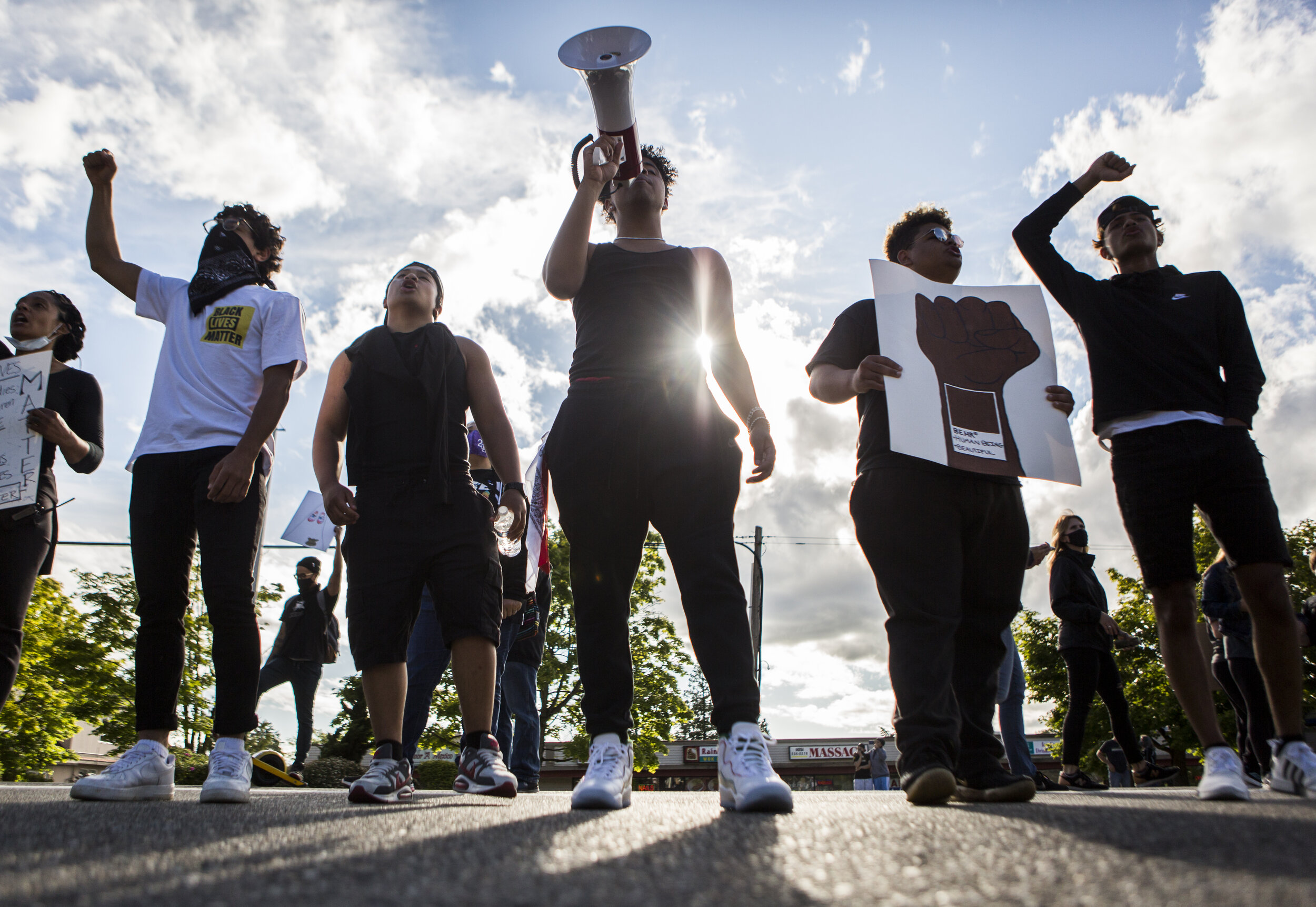  Local high school students Bilal Jaddi (left to right), Christian Ayson, Keyshon Rife, Daniel Jenkins and Cameron Asinsin lead the crowd in chants as hundreds of protestors arrive at the parking lot along 84th Street and Mukilteo Speedway during the