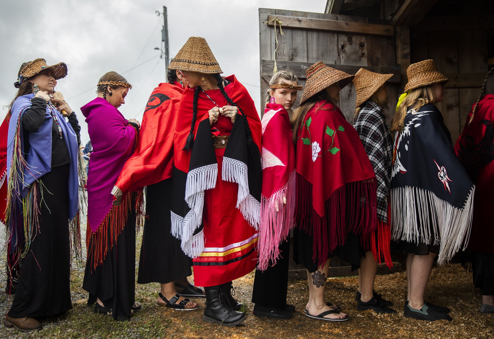  Dancers wait in a single file line to enter the longhouse for Salmon Ceremony on Saturday, June 11, 2022 in Tulalip, Washington. Over 100 people gathered on Tulalip Bay to welcome a visitor: yubəč, or the King Salmon. It was a joyous return of the a