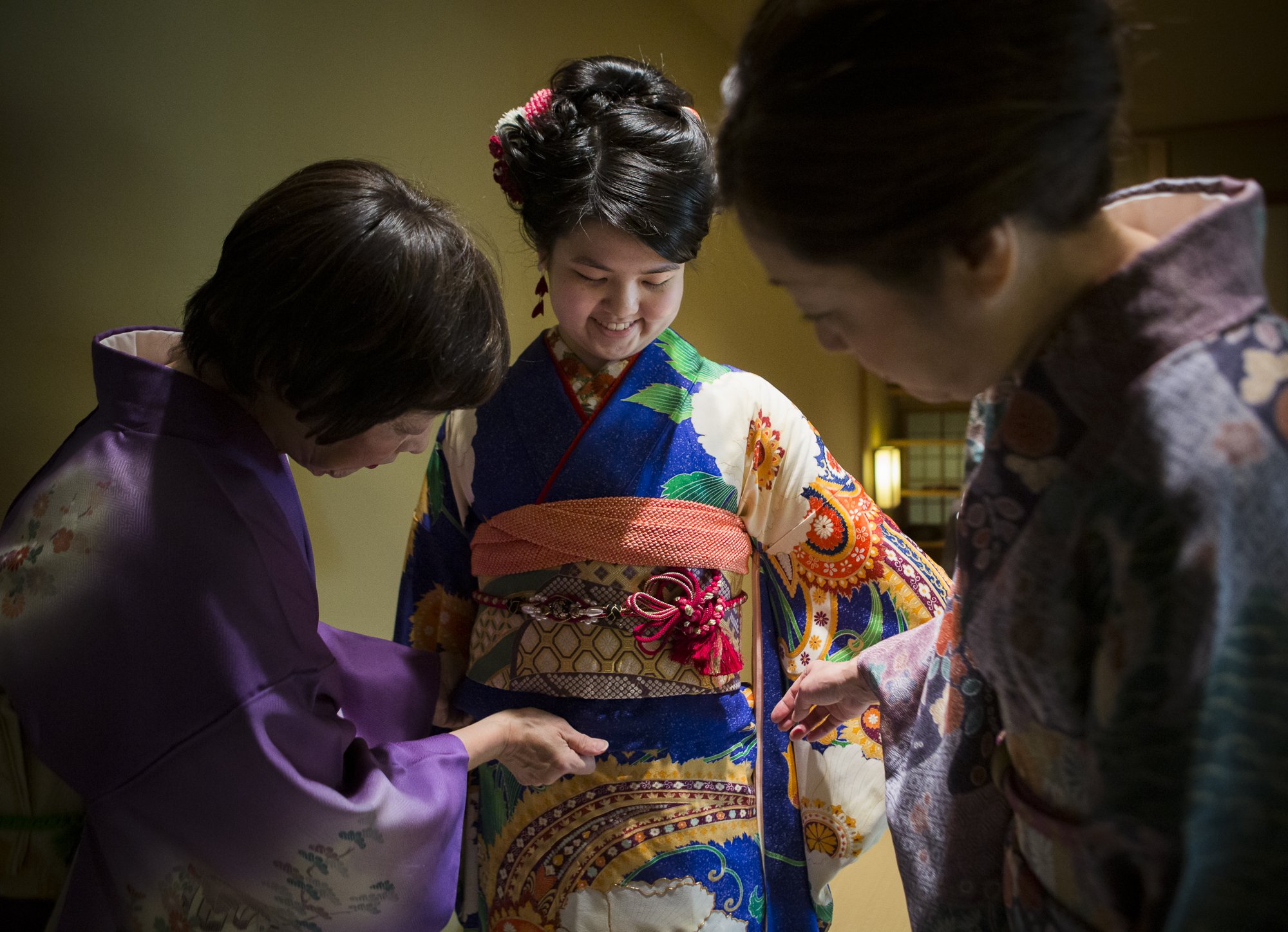  Kimono Art owners Yu Ugawa, left, and Mariko Kayama, right, help student Kotoko Miyamae, center, get fit in her kimono before a coming of age ceremony on Friday, Jan. 24, 2020 in Everett, Washington. As students turn 20, EvCC celebrates with Japanes