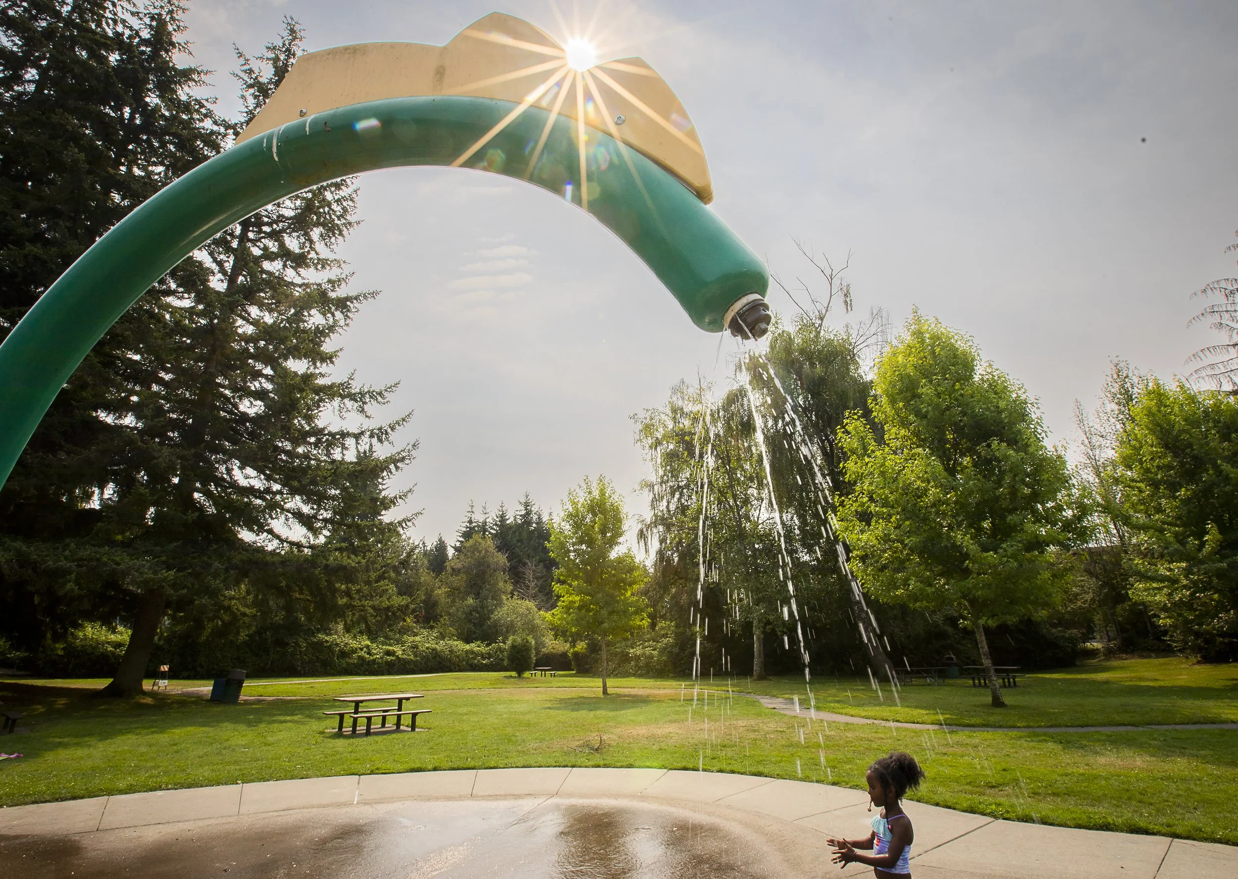  Bethayna Gebremariam, 6, is sprayed with water while the sun casts orange-tinged light across North Lynnwood Park on Friday, Aug. 9, 2024 in Lynnwood, Washington. The National Weather Service announced a heat advisory Friday for most counties along 