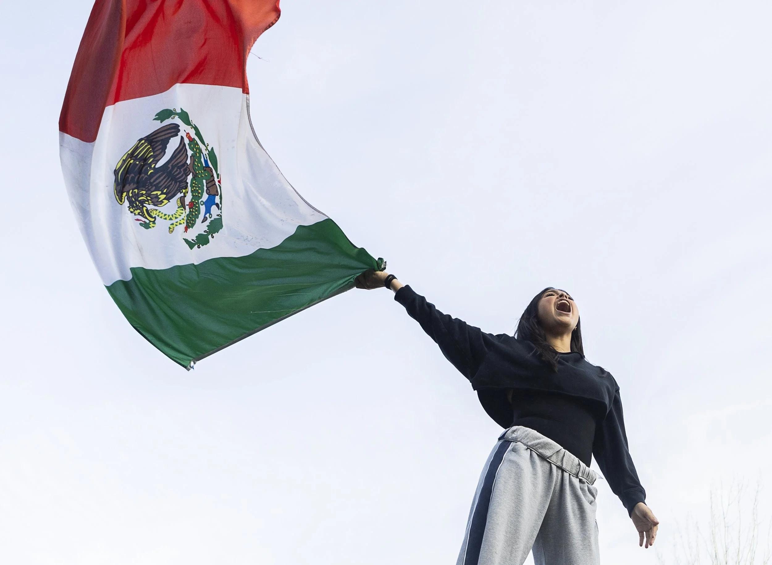  Venecia Cruz, a senior at Everett High School, yells and waves a Mexican flag during a walkout rally in protest of ICE outside of the Snohomish County Courthouse on Tuesday, Jan. 13, 2026, in Everett, Washington.&nbsp;Everett High School students wa