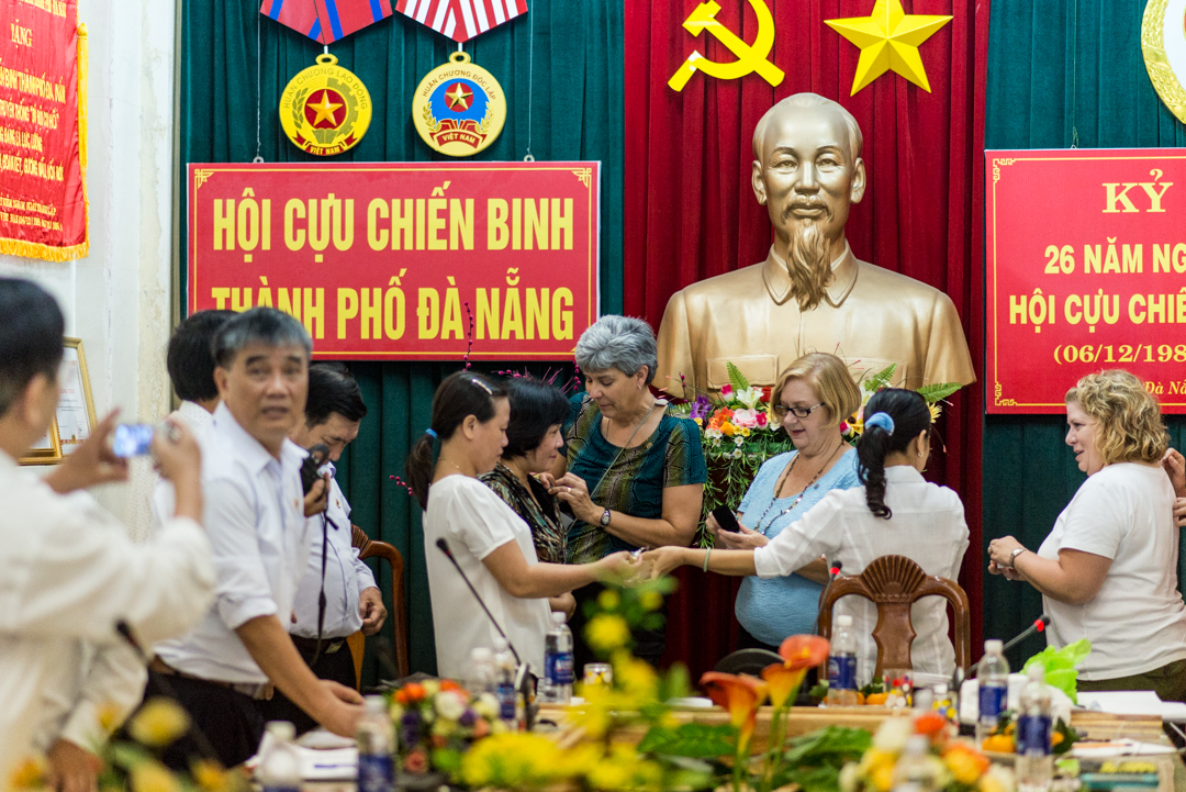 After the meeting, the daughters exchanged pins in front of a bust of Ho Chi Minh in the Da Nang Veterans Hall. Photo courtesy Istrico Productions. 