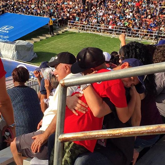 Ron Reyes embracing a boy whose father was killed in Iraq. 