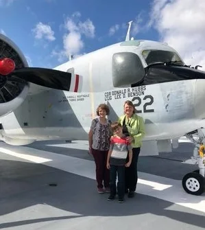 Jill, right, on the USS Yorktown next to a plane named in her father’s honor.