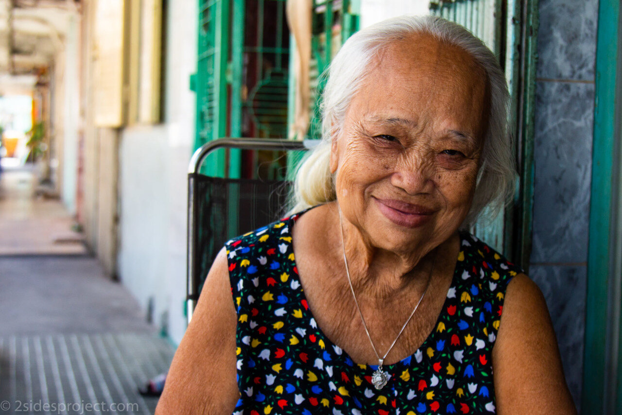 Photographs from the 2 Sides Project trips to Vietnam: Hoa, by Nora Kubach. “I toured the city in the early morning with photographer Quinn Ryan Mattingly. He took me to places I wouldn’t have known to go, where there are no Americans and no tourists. He taught me a lot about how to approach people you want to photograph. He said just go right up to them and start a conversation. We did that with Hoa. She told me she had worked at the airport during the war, that she loved her colleagues and loved the Americans. She showed us pictures of her grandchildren. It was instantly intimate. She had the same warm, friendly spirit of everybody we met. There's such a story in her face, this down to earth quality that I just thought was really sweet and beautiful.” Hoa and more stunning photographs from Vietnam are available in any size at http://bit.ly/2SwXK4n .