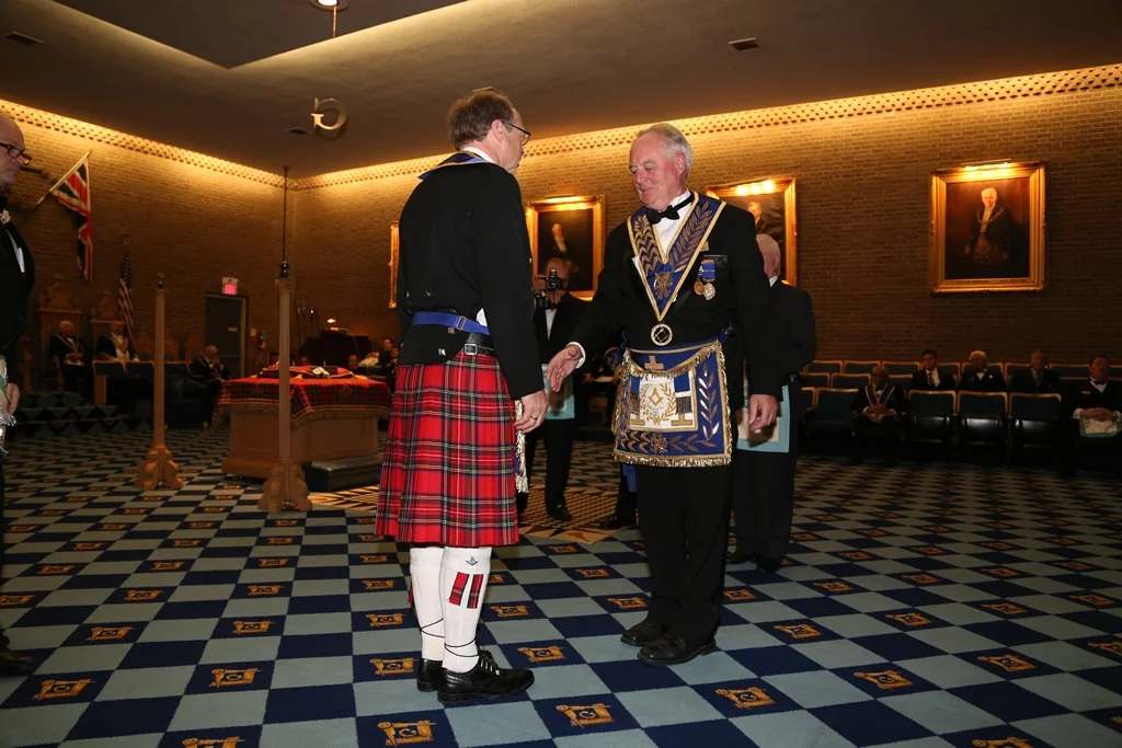 Alex has his apron Alan reaches to shake hands.jpg