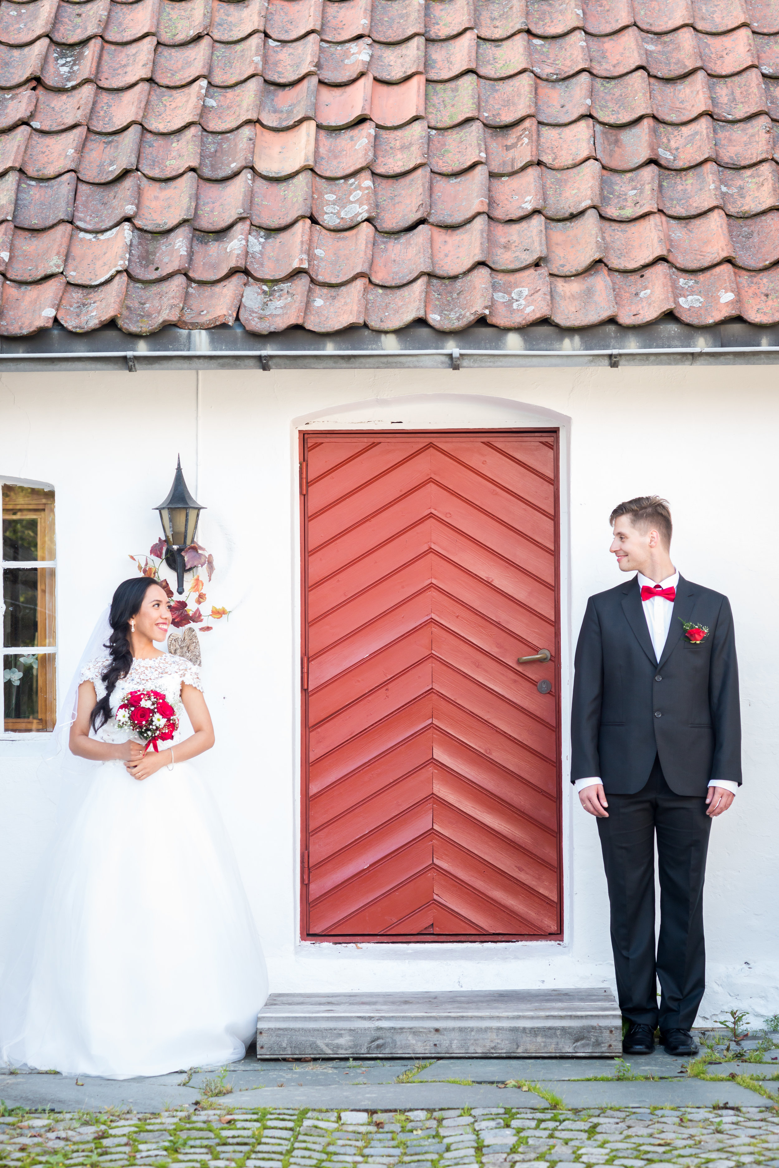 Bride and groom with a red door Stavanger wedding Guillem Cheung Bryllup