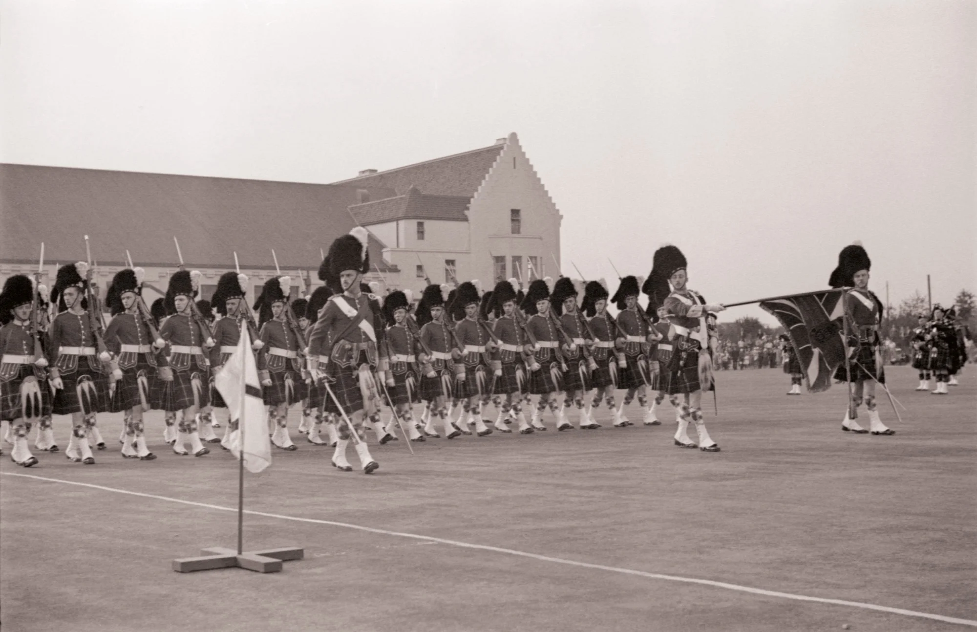 The reviewing party led by his Excellency, The Right Honourable Lord Tweedsmuir, G.C.M.G., C.H. Governor General of Canada. The Honourary Colonel, Major-General J.W. Stewart, C.B., C.M.G., is to the left of the reviewing line. Next to him, is Admiral Sir Matthew Best, K.C.B., D.S.O. & bar, M.V.O., Royal Navy, Commander-in-Chief, America and West Indies Station. Lady Tweedsmuir stands next to the Honourary Lieutentant-Colonel, Brigadier-General J.A. Clark, C.M.G., D.S.O., V.D. Behind the reviewing line can be seen Lieutenant-Colonel A.D. Wilson, D.S.O. V.D., the Seaforth’s Commanding Officer from 1924-1928, and at the extreme right of the frame in the bowler hat is architect Jack McCarter.