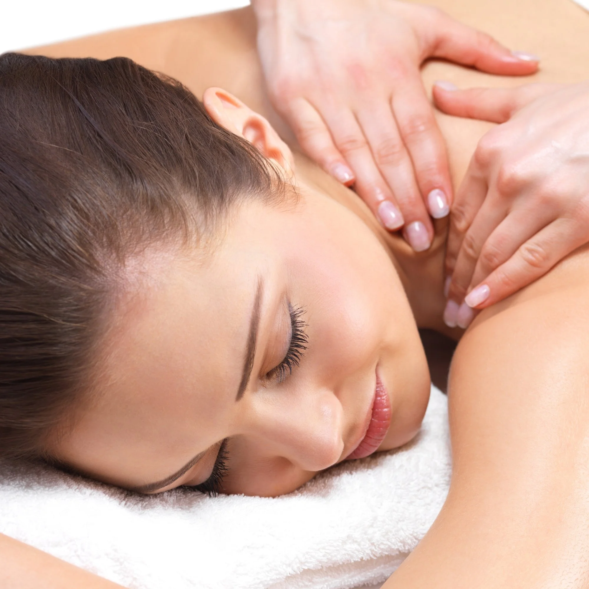 Woman receiving a back massage while lying on a massage table with a white towel.